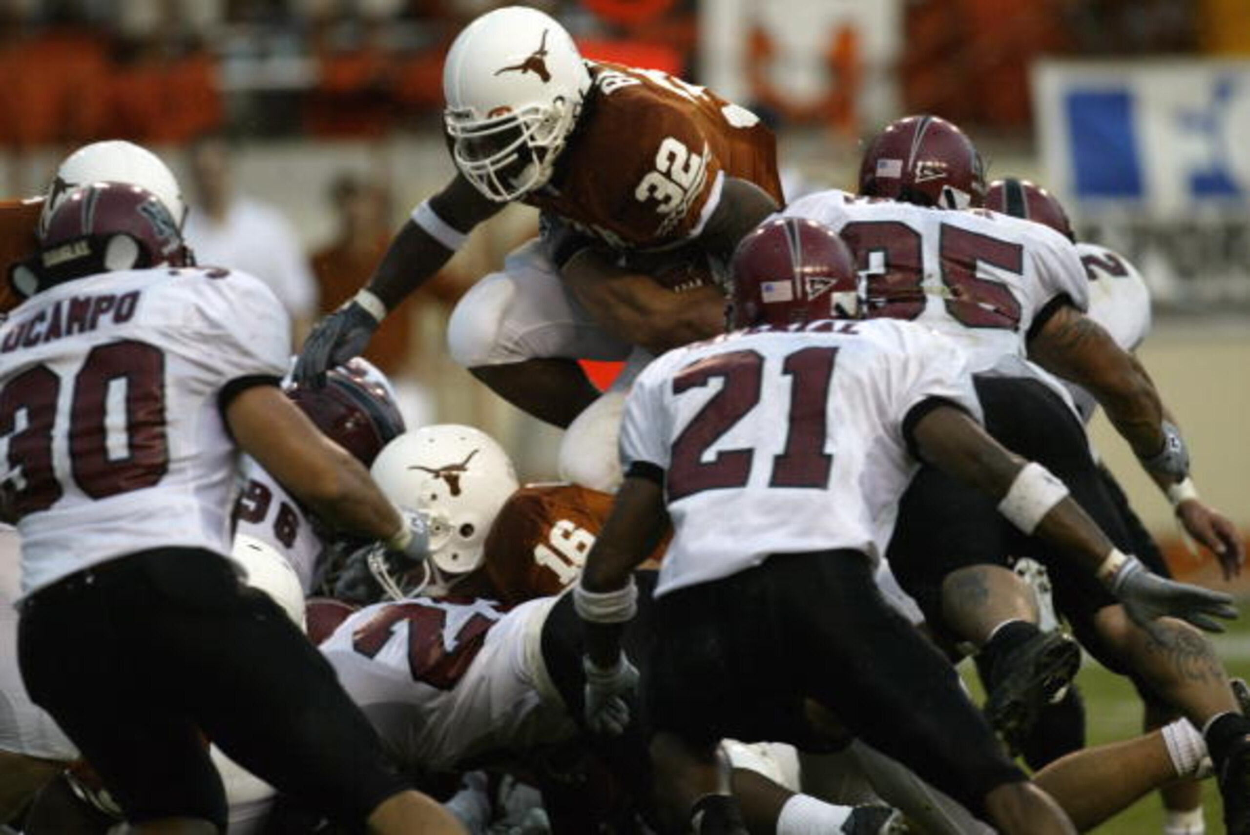 AUSTIN, TX - AUGUST 31: Running back Cedric Benson #32 of the University of Texas at Austin Longhorns leaps over the New Mexico State University Aggies during the game Texas Memorial Stadium on August 31, 2003 in Austin, Texas. Texas defeated New Mexico AUSTIN, TX - AUGUST 31: Running back Cedric Benson #32 of the University of Texas at Austin Longhorns leaps over the New Mexico State University Aggies during the game Texas Memorial Stadium on August 31, 2003 in Austin, Texas. Texas defeated New Mexico