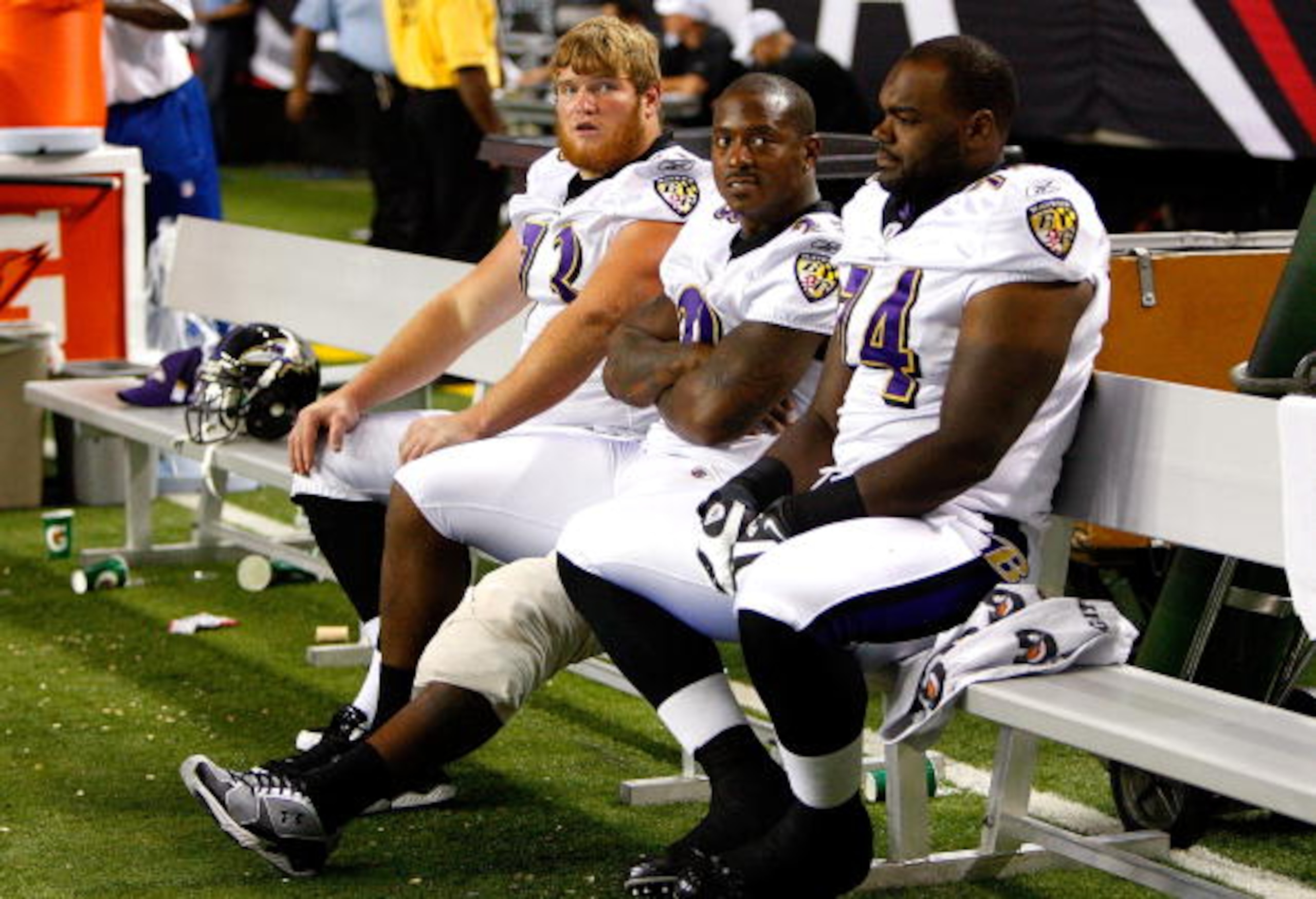 ATLANTA - SEPTEMBER 03:  Running back Willis McGahee #23 of the Baltimore Raves sits on the bench with ice on his left knee between Marshal Yanda #73 and Michael Oher #74 during their preseason game against the Atlanta Falcons at Georgia Dome on September