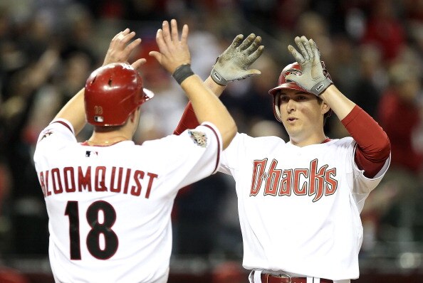 PHOENIX, AZ - APRIL 08:  Kelly Johnson #2 of the Arizona Diamondbacks high fives teammate Willie Bloomquist #18 after Johnson hit a 3 run home run against the Cincinnati Reds during the eighth inning of the Major League Baseball home opening game at Chase