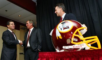 ASHBURN, VA - JANUARY 06:  Mike Shanahan (C) shakes hands with Washington Redskins owner Daniel Snyder (L) as General Manager Bruce Allen (R) looks on before Shanahan was announced as the new head coach of the Washington Redskins on January 6, 2010 in Ash