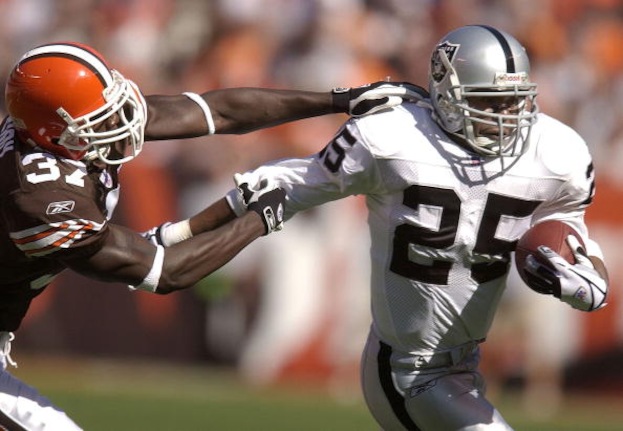 CLEVELAND, OH - OCTOBER 12:  Anthony Henry #37 of the Cleveland Browns pursues Charlie Garner #25 of the Oakland Raiders during the first quarter on October 12, 2003 at Cleveland Browns Stadium in Cleveland, Ohio.  (Photo by David Maxwell/Getty Images)