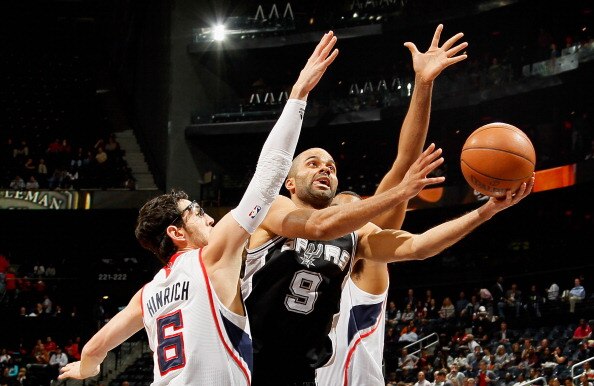 ATLANTA, GA - APRIL 05:  Tony Parker #9 of the San Antonio Spurs lays in a basket against Kirk Hinrich #6 of the Atlanta Hawks at Philips Arena on April 5, 2011 in Atlanta, Georgia.  NOTE TO USER: User expressly acknowledges and agrees that, by downloadin