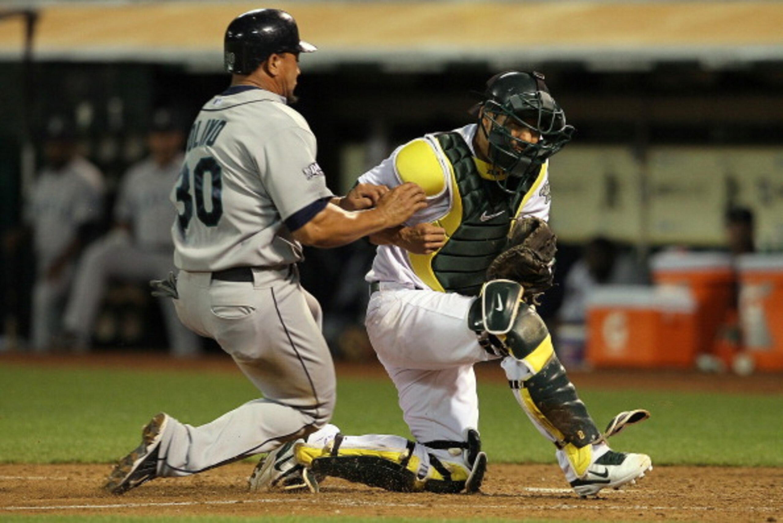 OAKLAND, CA - APRIL 01:  Miguel Olivo #30 of the Seattle Mariners collides with Kurt Suzuki #8 of the Oakland Athletics during the seventh inning at the Oakland-Alameda County Coliseum on April 1, 2011 in Oakland, California. Olivio was safe on the play.