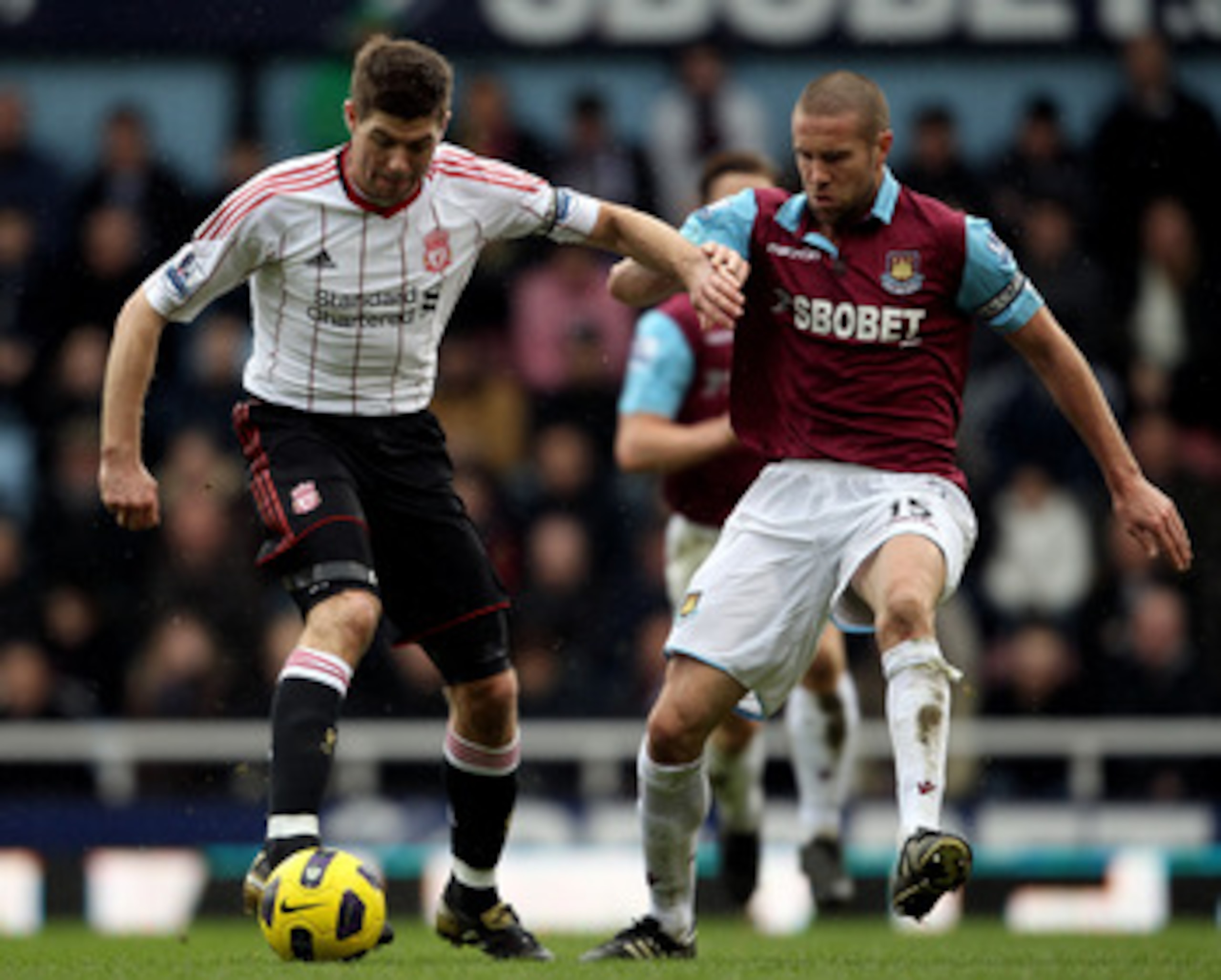 LONDON, ENGLAND - FEBRUARY 27:  Steven Gerrard of Liverpool is challenged by Matthew Upson of West Ham during the Barclays Premier League match between West Ham United and Liverpool at the Boleyn Ground on February 27, 2011 in London, England.  (Photo by