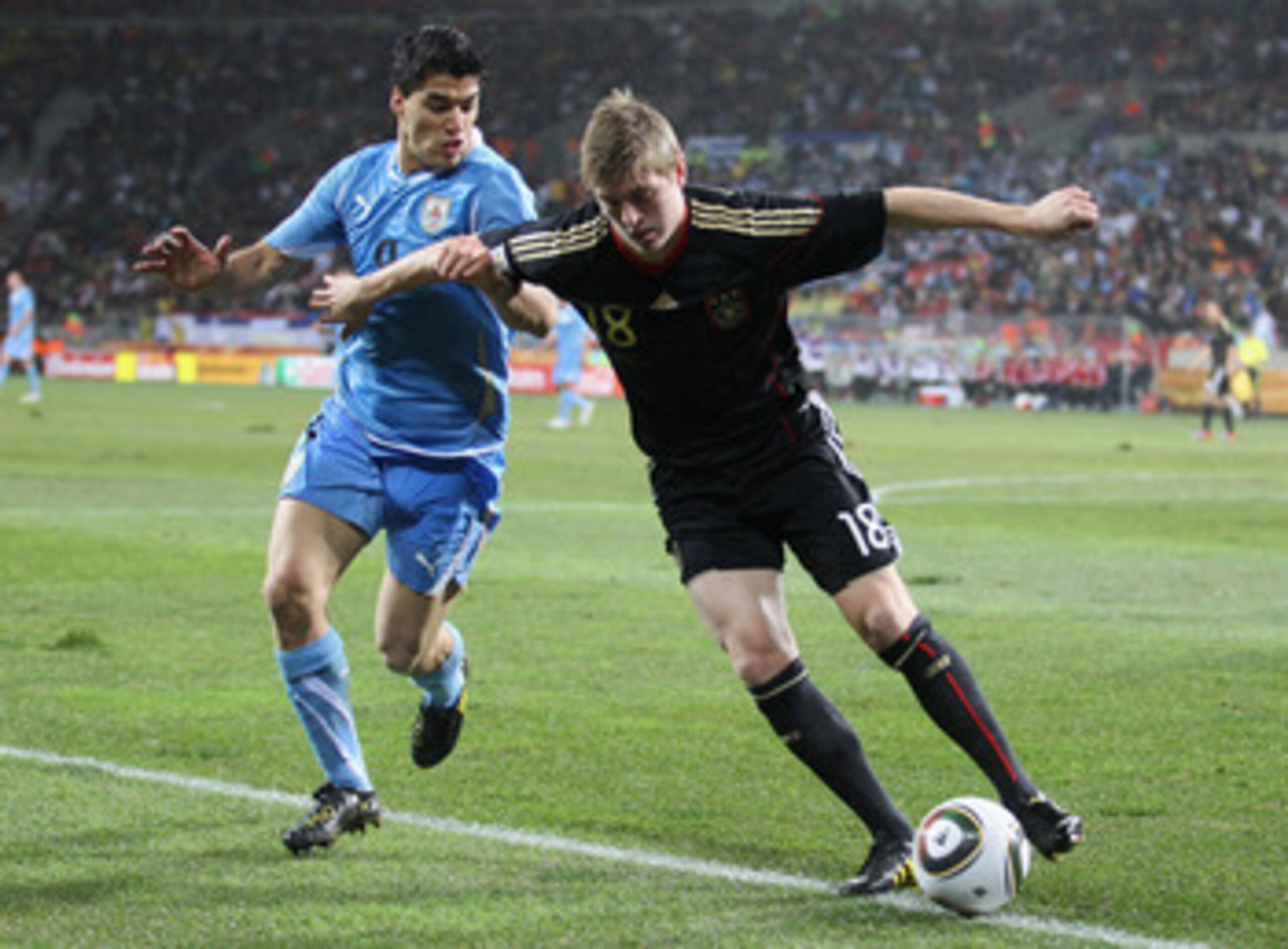 PORT ELIZABETH, SOUTH AFRICA - JULY 10:  Luis Suarez of Uruguay tussles for posession with Toni Kroos of Germany during the 2010 FIFA World Cup South Africa Third Place Play-off match between Uruguay and Germany at The Nelson Mandela Bay Stadium on July 1