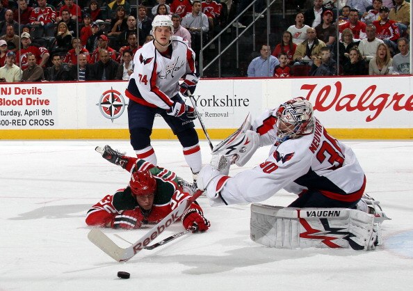 NEWARK, NJ - MARCH 18: Michal Neuvirth #30 of the Washington Capitals shoots the puck away from Nick Palmieri #32 of the New Jersey Devils at the Prudential Center on March 18, 2011 in Newark, New Jersey.  (Photo by Bruce Bennett/Getty Images)