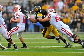 IOWA CITY, IA - OCTOBER 23- Quarterback Scott Tolzien #16 of the Wisconsin Badgers throws under pressure from Defensive lineman Adrian Clayborn #94 of the University of Iowa Hawkeyes as offensive lineman Gabe Carimi #68 defends during the first half of pl