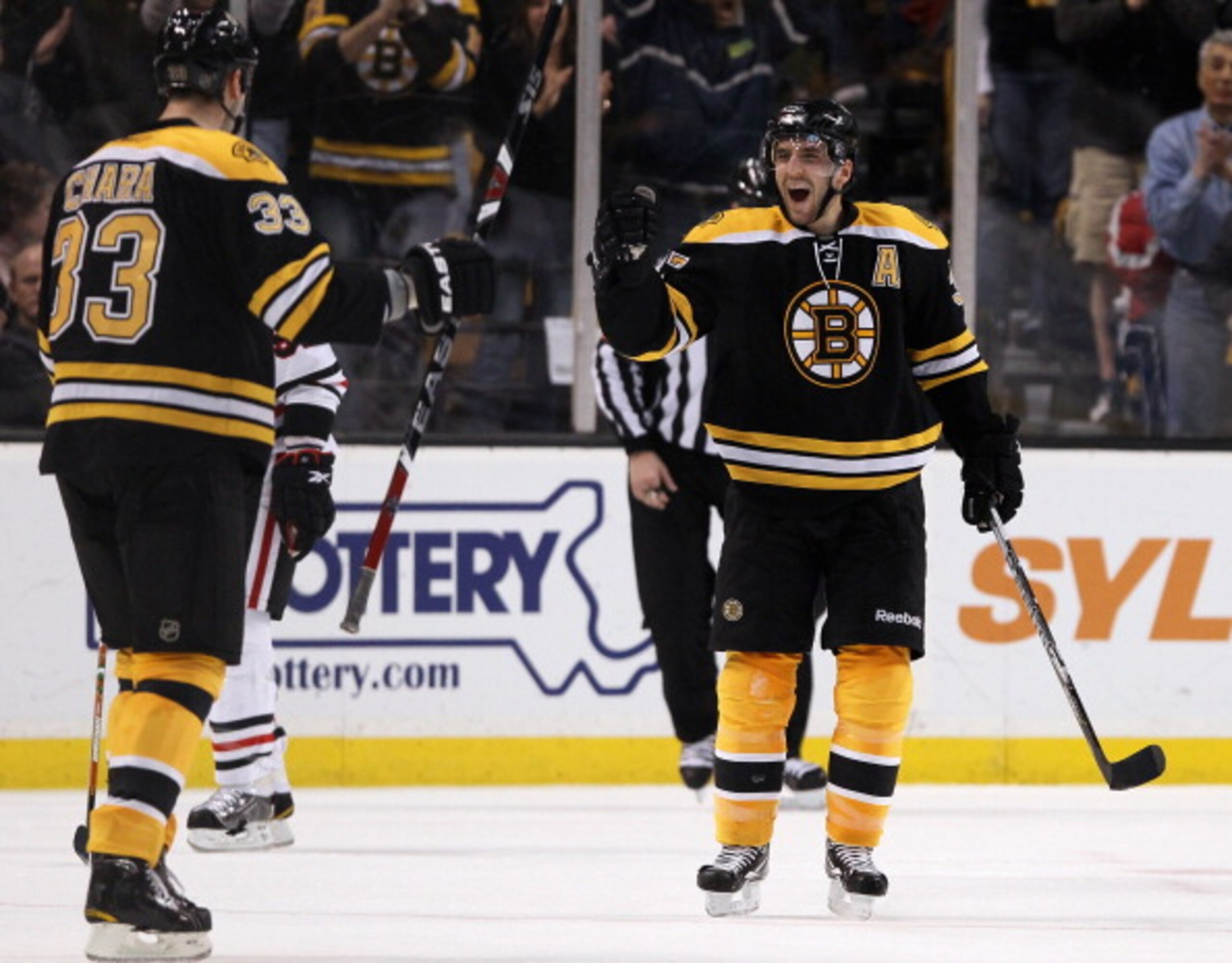 BOSTON, MA - MARCH 29:  Patrice Bergeron #37 of the Boston Bruins congratulates teammate Zdeno Chara #33 after Chara scored the first goal of the game against the Chicago Blackhawks on March 29, 2011 at the TD Garden in Boston, Massachusetts.  (Photo by E