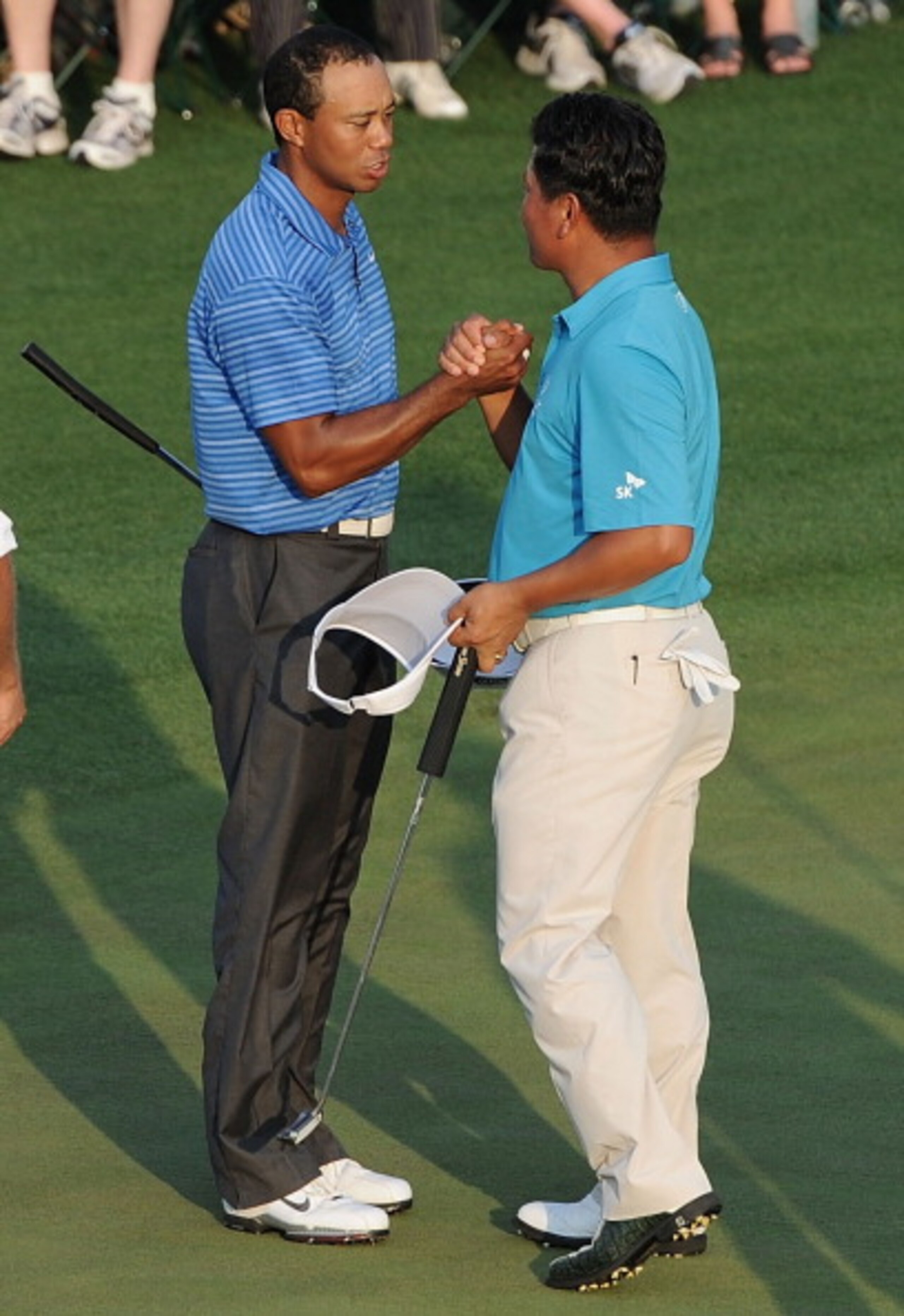 AUGUSTA, GA - APRIL 09:  Tiger Woods (L) shakes hands with K.J. Choi of South Korea on the 18th green during the third round of the 2011 Masters Tournament at Augusta National Golf Club on April 9, 2011 in Augusta, Georgia.  (Photo by Harry How/Getty Imag