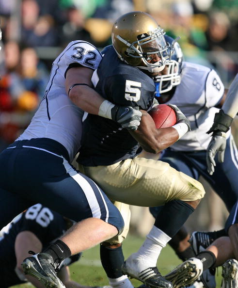 SOUTH BEND, IN - NOVEMBER 21: Armando Allen #5 of the Notre Dame Fighting Irish is stopped by Scott Lutrus #5 of the Univeristy of Connecticut Huskies at Notre Dame Stadium on November 21, 2009 in South Bend, Indiana. (Photo by Jonathan Daniel/Getty Image