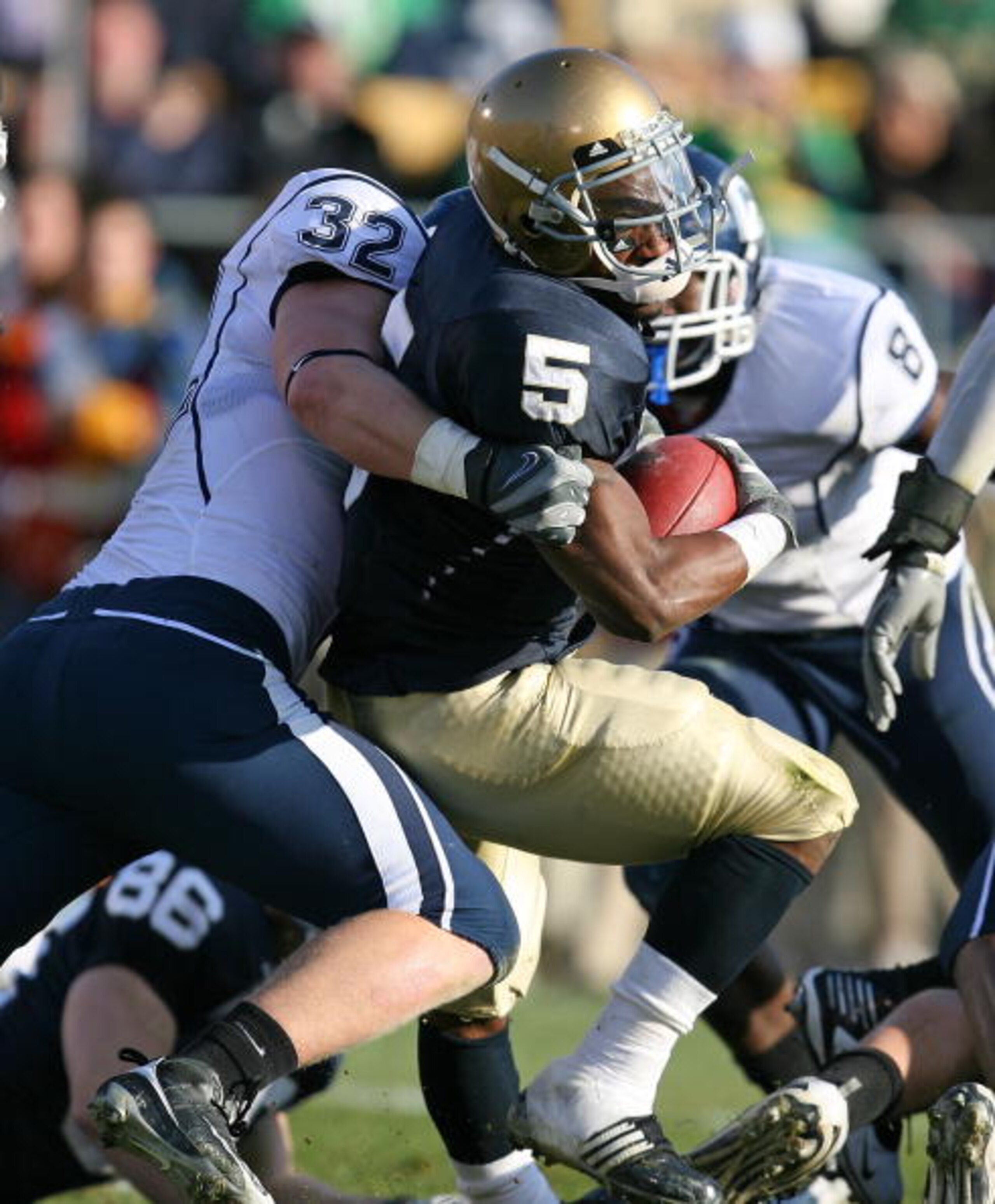SOUTH BEND, IN - NOVEMBER 21: Armando Allen #5 of the Notre Dame Fighting Irish is stopped by Scott Lutrus #5 of the Univeristy of Connecticut Huskies at Notre Dame Stadium on November 21, 2009 in South Bend, Indiana. (Photo by Jonathan Daniel/Getty Image