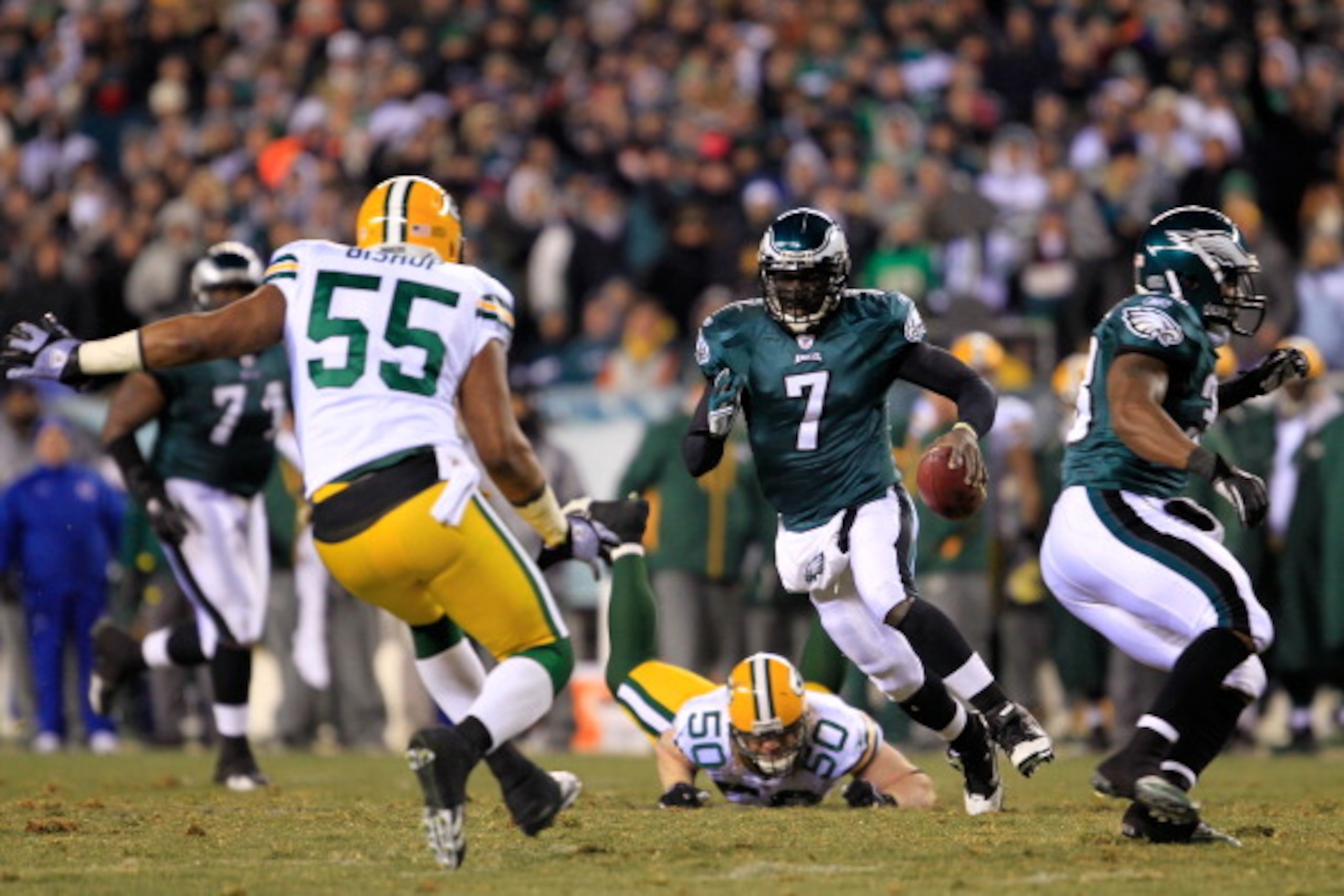 PHILADELPHIA, PA - JANUARY 09:  Michael Vick #7 of the Philadelphia Eagles scrambles against A.J. Hawk #50 and Desmond Bishop #55 of the Green Bay Packers during the 2011 NFC wild card playoff game at Lincoln Financial Field on January 9, 2011 in Philadel