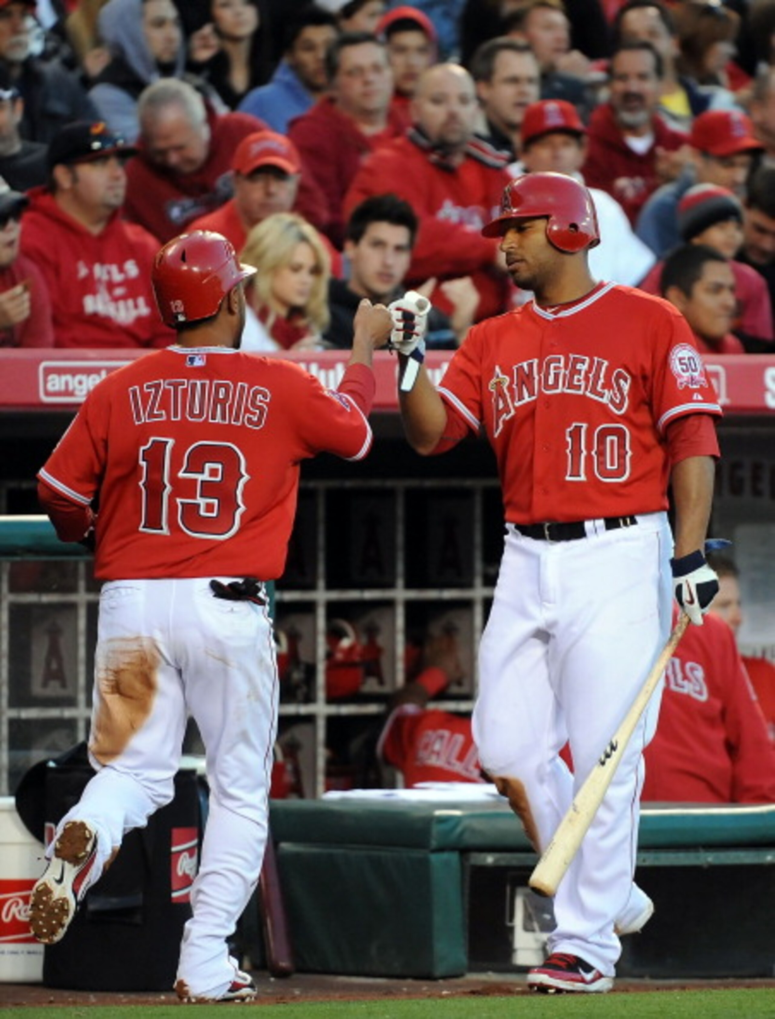 ANAHEIM, CA - APRIL 09:  (L-R)Maicer Izturis #13 celebrates with Vernon Wells #10 of Los Angeles Angels of Anaheim after scoring in the third inning against the Toronto Blue Jays at Angel Stadium of Anaheim on April 9, 2011 in Anaheim, California.  (Photo