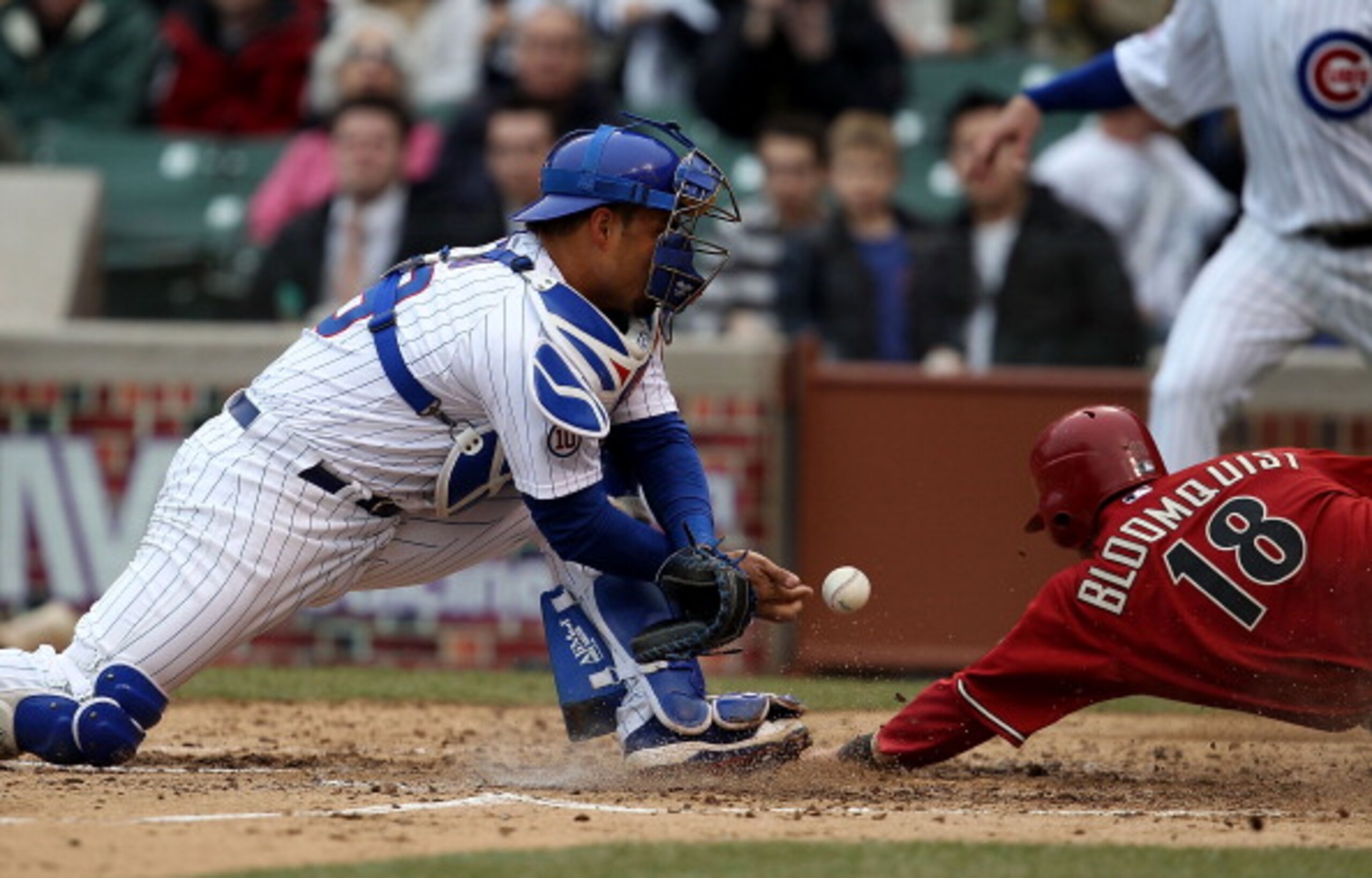 CHICAGO, IL - APRIL 06: Geovany Soto #18 of the Chicago Cubs drops the ball for an error as Willie Bloomquist #18 of the Arizona Diamondbacks slides in to score in the 5th inning at Wrigley Field on April 6, 2011 in Chicago, Illinois. (Photo by Jonathan D