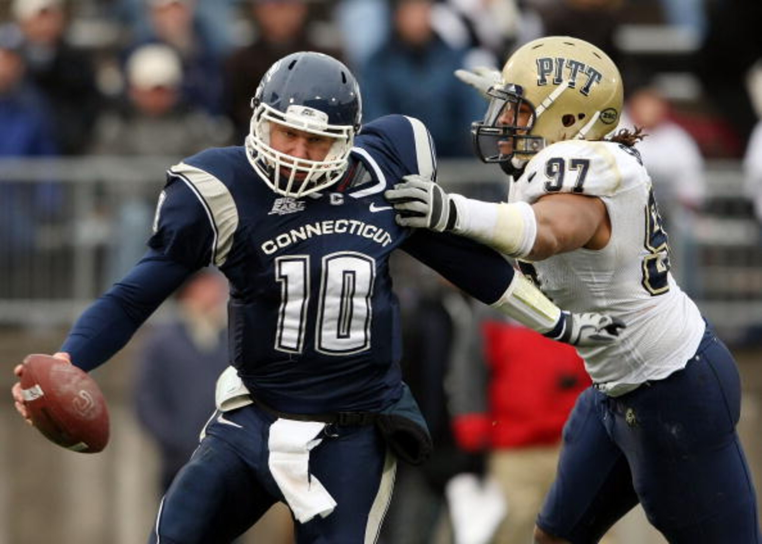 EAST HARTFORD, CT - DECEMBER 06:  Zach Frazer #10 of the Connecticut Huskies narrowly escapes Jabaal Sheard #97 of the Pittsburgh Panthers on December 6, 2008 at Rentschler Field in East Hartford, Connecticut. The Panthers defeated the Huskies 34-10.  (Ph