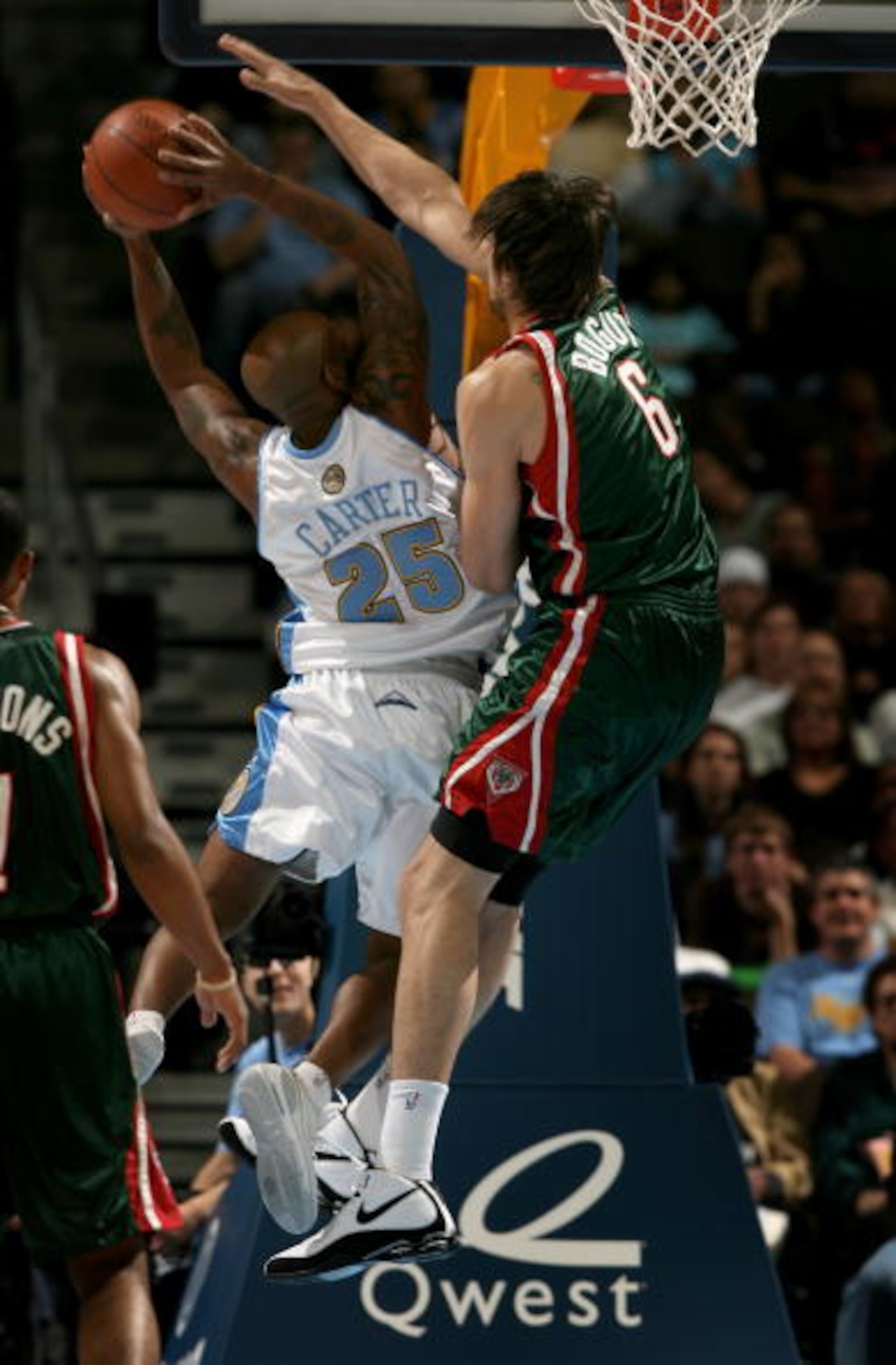 DENVER - NOVEMBER 18:  Anthony Carter #25 of the Denver Nuggets scores a basket despite the defense of Andrew Bogut #6 of the Milwaukee Bucks at the Pepsi Center on November 18, 2008 in Denver, Colorado. The Nuggets defeated the Bucks 114-105.  (Photo by