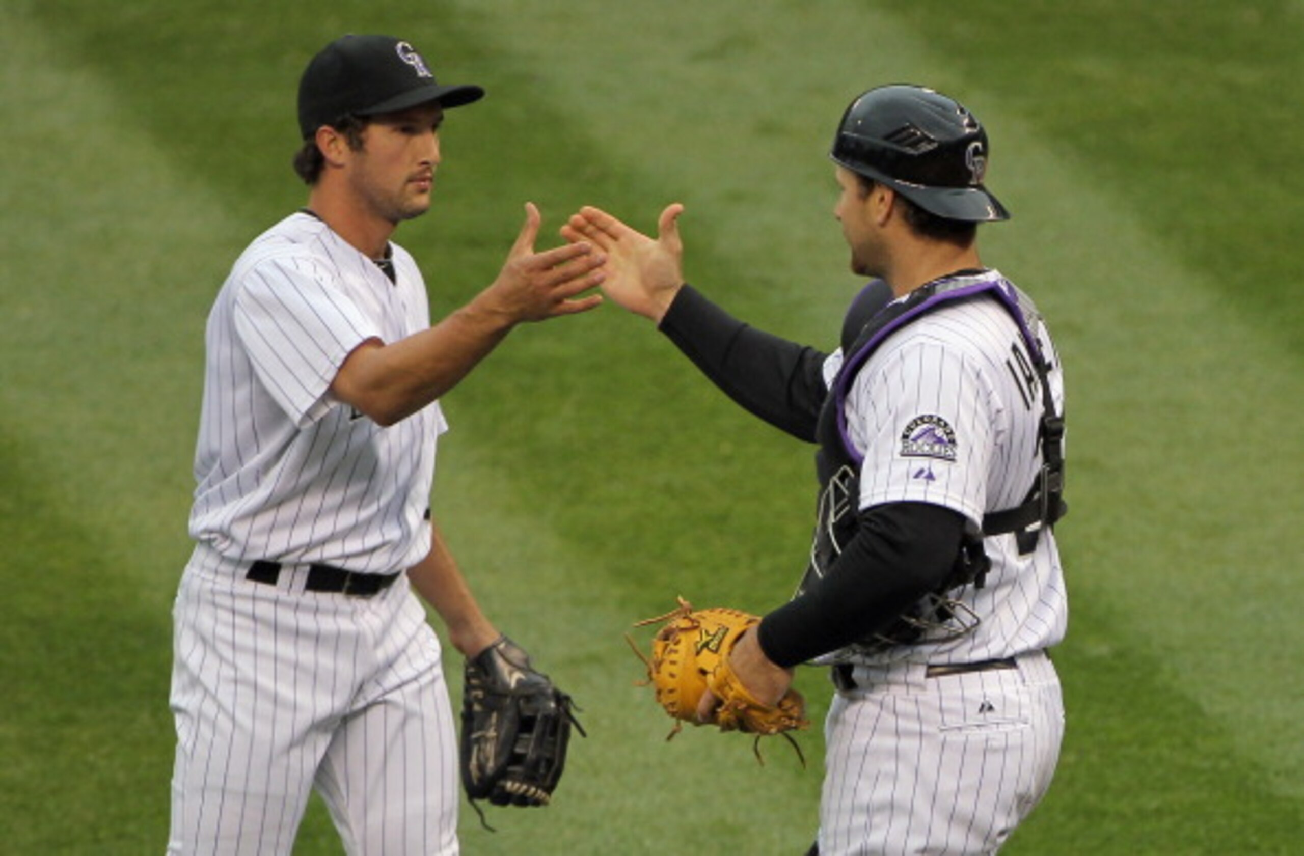DENVER, CO - APRIL 06:  Pitcher Huston Street #16 of the Colorado Rockies and catcher Chris Iannetta #20 of the Colorado Rockies celebrate their vctory over the Los Angeles Dodgers at Coors Field on April 6, 2011 in Denver, Colorado. Street earned his thi