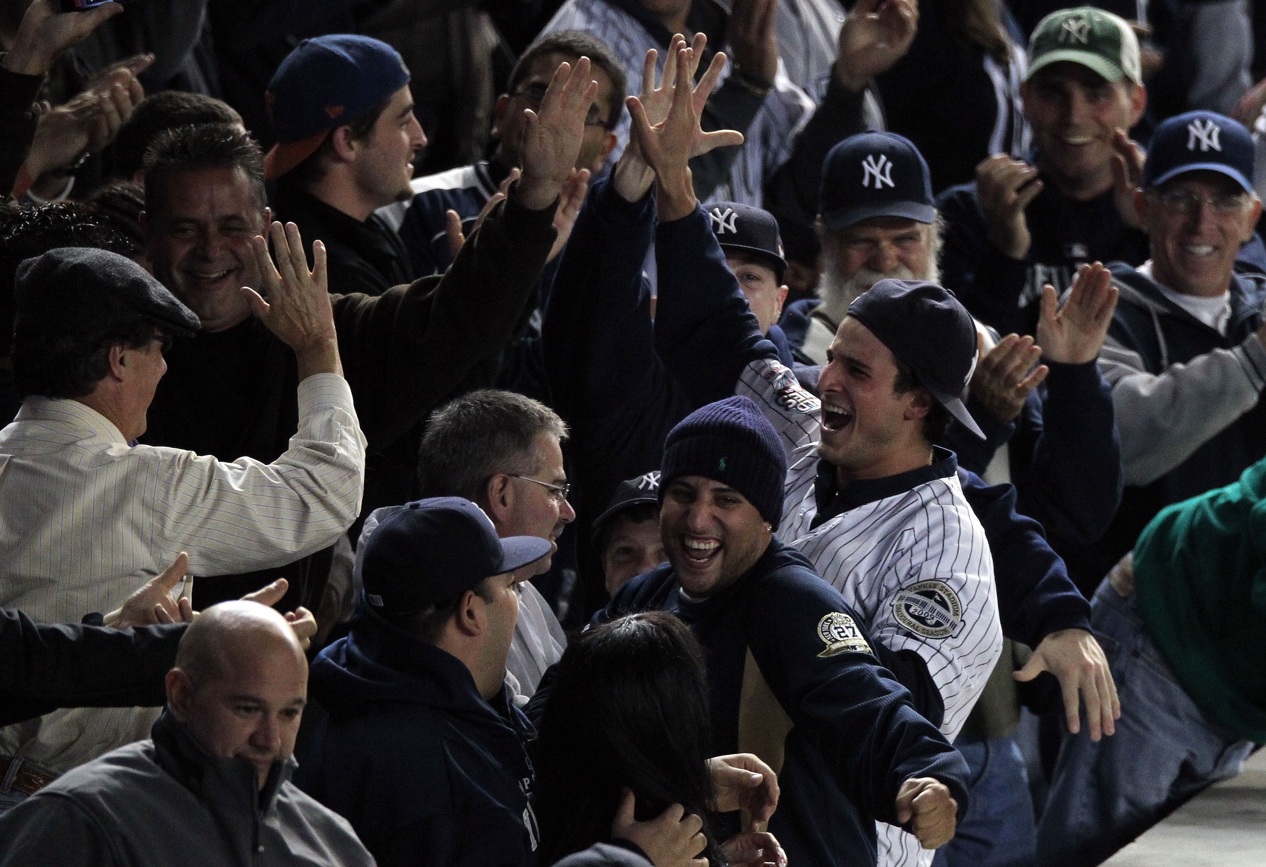 NEW YORK - OCTOBER 19:  A fan (R) of the New York Yankees reacts after he caught a home run ball hit by Robinson Cano #24 of the Yankees in the bottom of the seocnd inning against the Texas Rangers in Game Four of the ALCS during the 2010 MLB Playoffs at