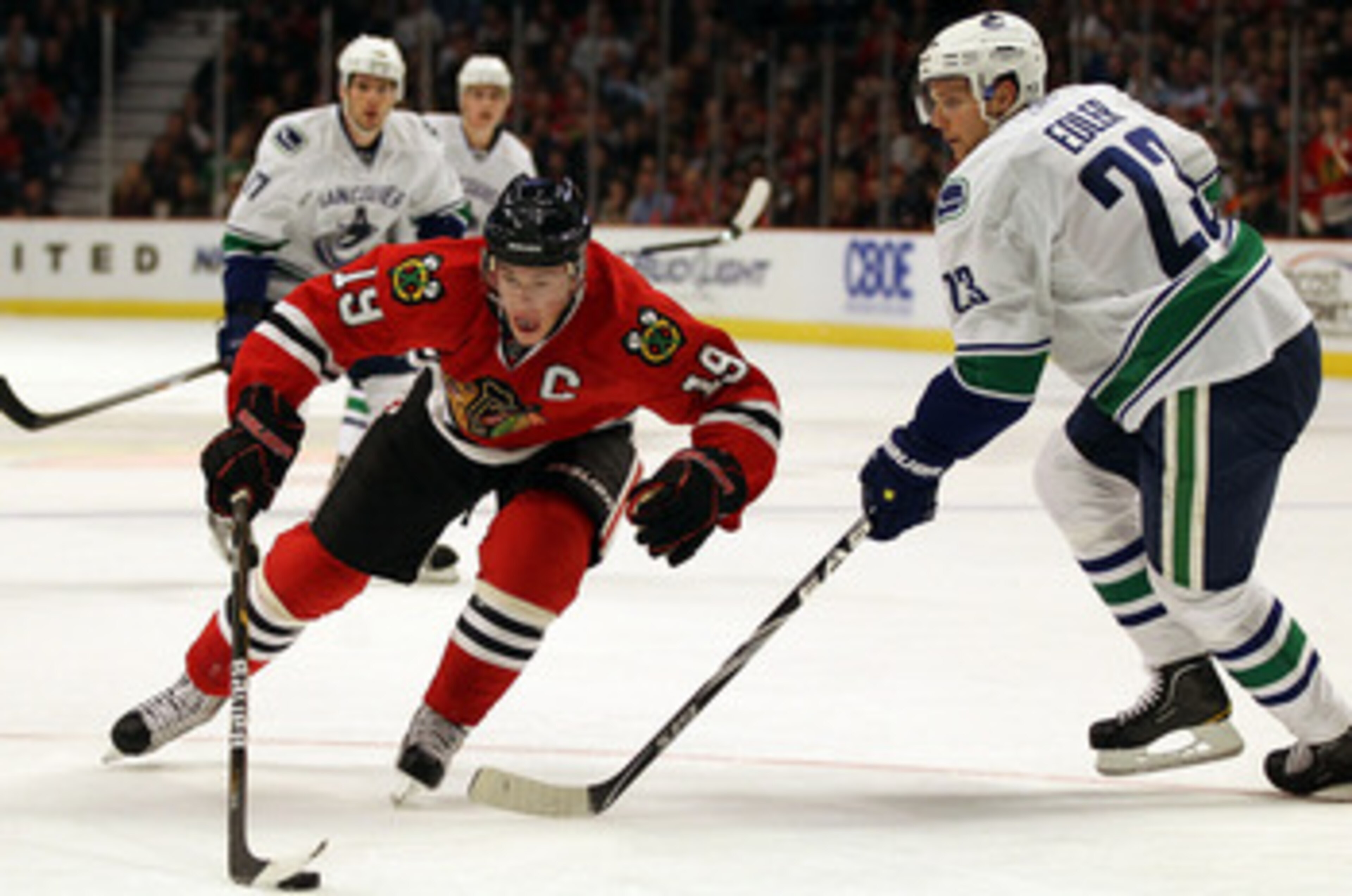CHICAGO, IL - DECEMBER 03: Jonathan Toews #19 of the Chicago Blackhawks controls the puck against Alexander Edler #23 of the Vancouver Canucks at the United Center on December 3, 2010 in Chicago, Illinois. The Canucks defeated the Blackhawks 3-0. (Photo CHICAGO, IL - DECEMBER 03: Jonathan Toews #19 of the Chicago Blackhawks controls the puck against Alexander Edler #23 of the Vancouver Canucks at the United Center on December 3, 2010 in Chicago, Illinois. The Canucks defeated the Blackhawks 3-0. (Photo