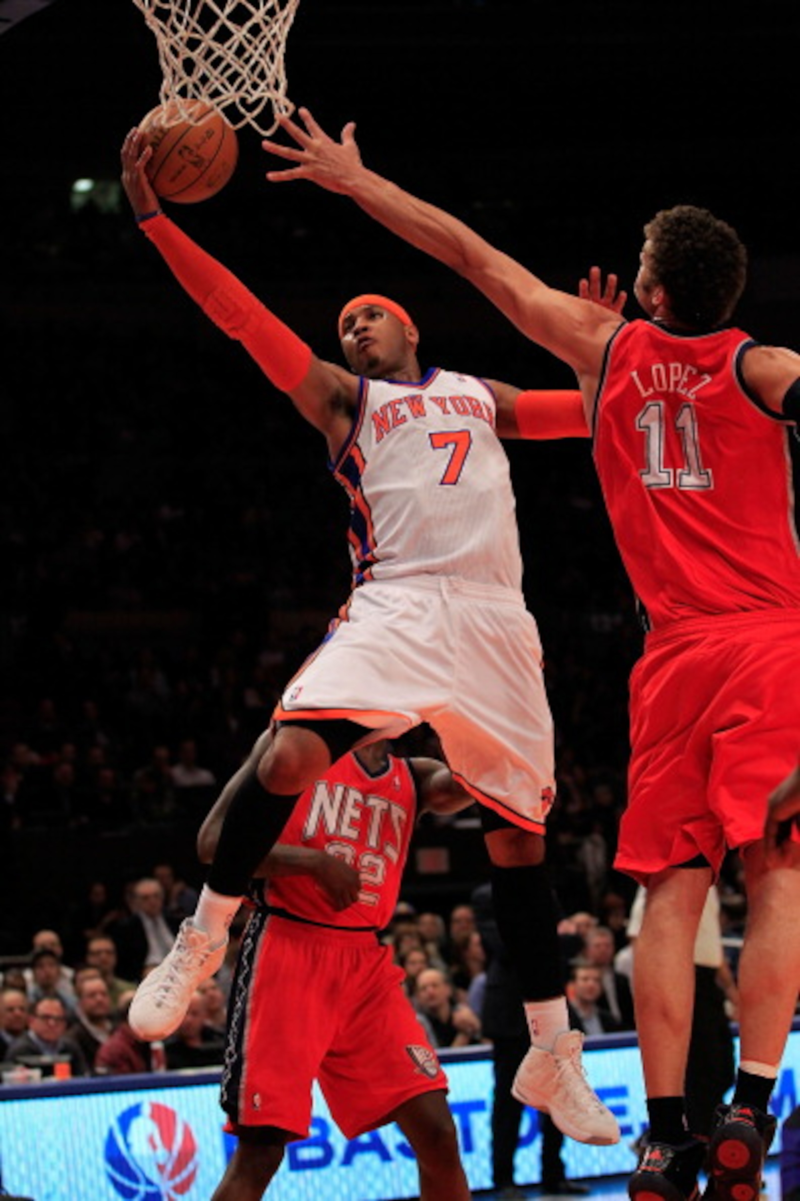 NEW YORK, NY - MARCH 30: Carmelo Anthony #7 of the New York Knicks shoots over Brook Lopez #11 of the New Jersey Nets at Madison Square Garden on March 30, 2011 in New York City. NOTE TO USER: User expressly acknowledges and agrees that, by downloading an