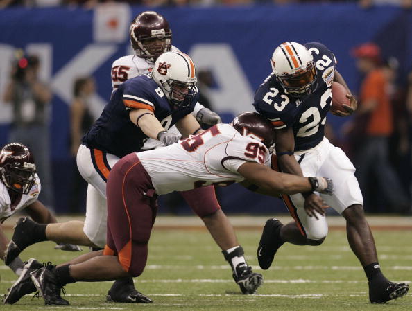 NEW ORLEANS - JANUARY 03:  Running back Ronnie Brown #23 of the Auburn Tigers avoids the tackle of Jim Davis #95 of the Virginia Tech Hokies during the Nokia Sugar Bowl on January 3, 2005 at the Superdome in New Orleans, Louisiana.  (Photo by Chris Grayth