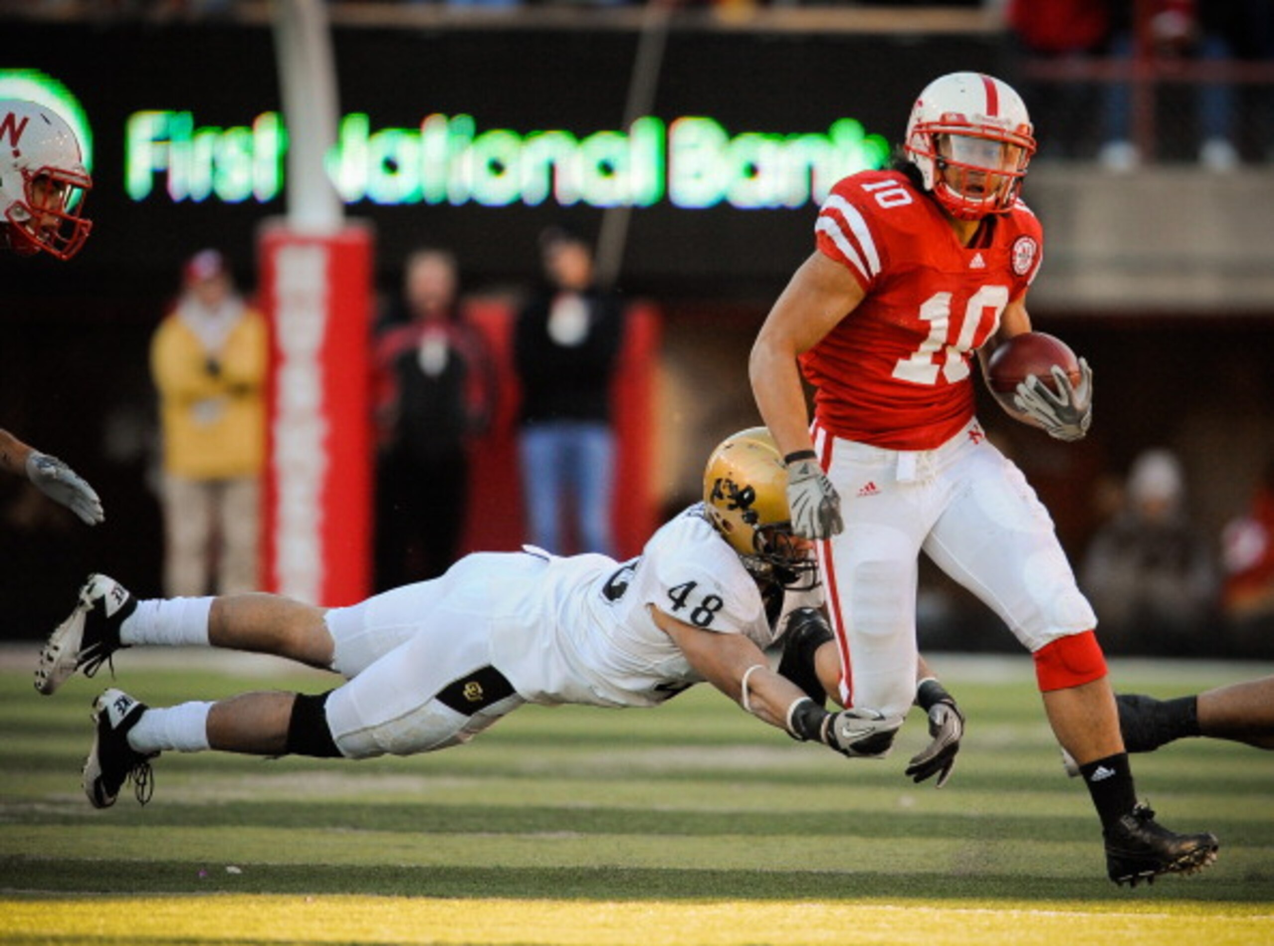 LINCOLN, NE - NOVEMBER 26: Roy Helu Jr. #10 of the Nebraska Cornhuskers runs past Liloa Nobriga #48 of the Colorado Buffaloes during the first half of their game at Memorial Stadium on November 26, 2010 in Lincoln, Nebraska. Nebraska defeated Colorado 45- LINCOLN, NE - NOVEMBER 26: Roy Helu Jr. #10 of the Nebraska Cornhuskers runs past Liloa Nobriga #48 of the Colorado Buffaloes during the first half of their game at Memorial Stadium on November 26, 2010 in Lincoln, Nebraska. Nebraska defeated Colorado 45-