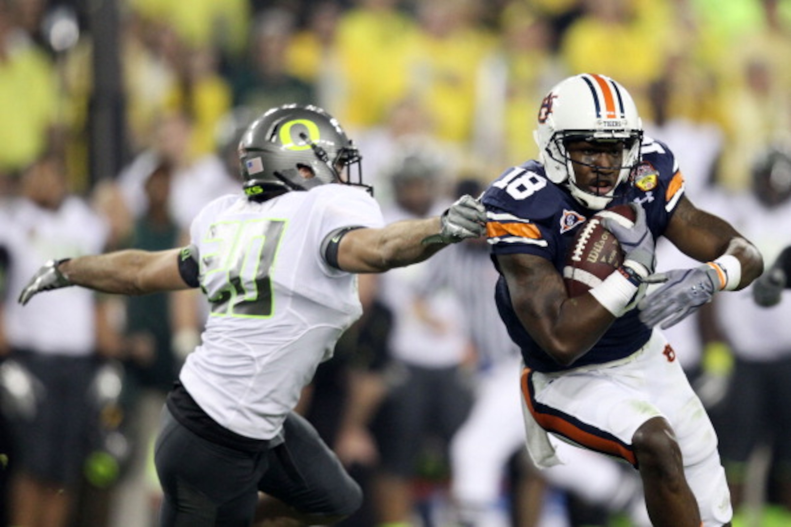 GLENDALE, AZ - JANUARY 10:  Kodi Burns #18 of the Auburn Tigers tries to avoid the tackle of John Boyett #20 of the Oregon Ducks during the Tostitos BCS National Championship Game at University of Phoenix Stadium on January 10, 2011 in Glendale, Arizona.