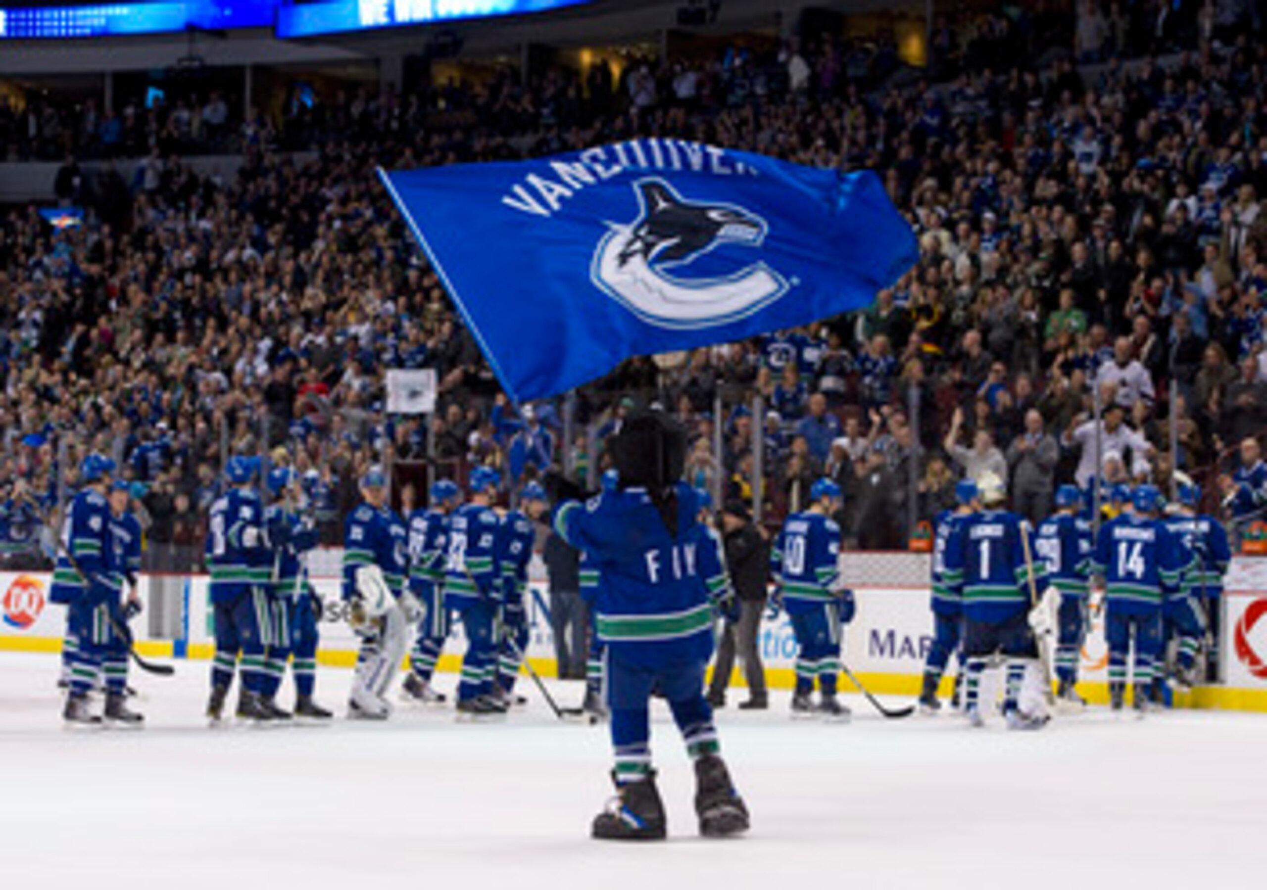 VANCOUVER, CANADA - MARCH 31: Vancouver Canucks mascot Fin waves a team flag after the Vancouver Canucks defeated the Los Angeles Kings in NHL action on March 31, 2011 at Rogers Arena in Vancouver, BC, Canada.  (Photo by Rich Lam/Getty Images)