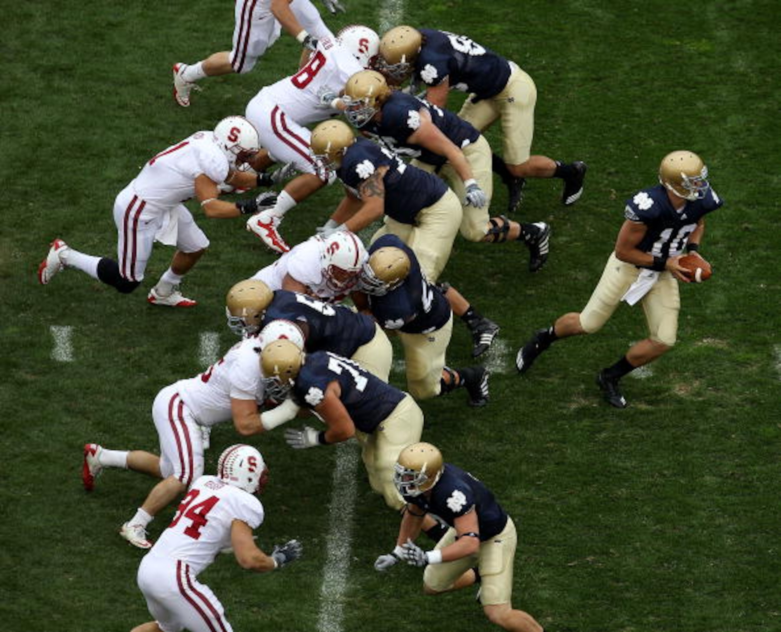 SOUTH BEND, IN - SEPTEMBER 25: Dayne Crist #10 of the Notre Dame Fighting Irish turns to hand-off as his offensive line blocks against the Stanford Cardinal defense at Notre Dame Stadium on September 25, 2010 in South Bend, Indiana. Standford defeated Not SOUTH BEND, IN - SEPTEMBER 25: Dayne Crist #10 of the Notre Dame Fighting Irish turns to hand-off as his offensive line blocks against the Stanford Cardinal defense at Notre Dame Stadium on September 25, 2010 in South Bend, Indiana. Standford defeated Not