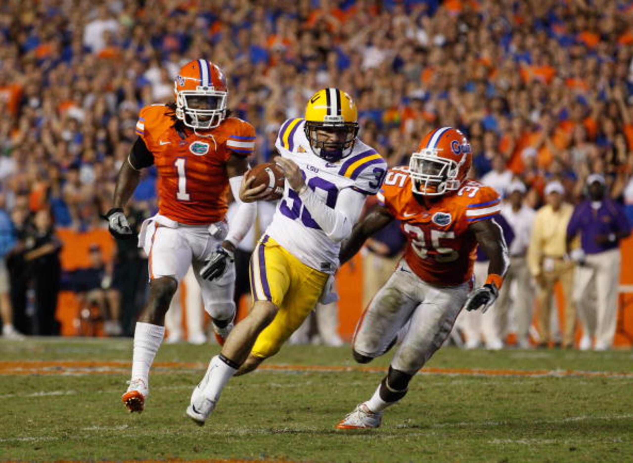 GAINESVILLE, FL - OCTOBER 09: Punter Josh Jasper #30 of the Louisiana State University Tigers runs a fake punt for yardage past Ahmad Black #35 and Janoris Jenkins #1 of the Florida Gators during the game at Ben Hill Griffin Stadium on October 9, 2010 in GAINESVILLE, FL - OCTOBER 09: Punter Josh Jasper #30 of the Louisiana State University Tigers runs a fake punt for yardage past Ahmad Black #35 and Janoris Jenkins #1 of the Florida Gators during the game at Ben Hill Griffin Stadium on October 9, 2010 in