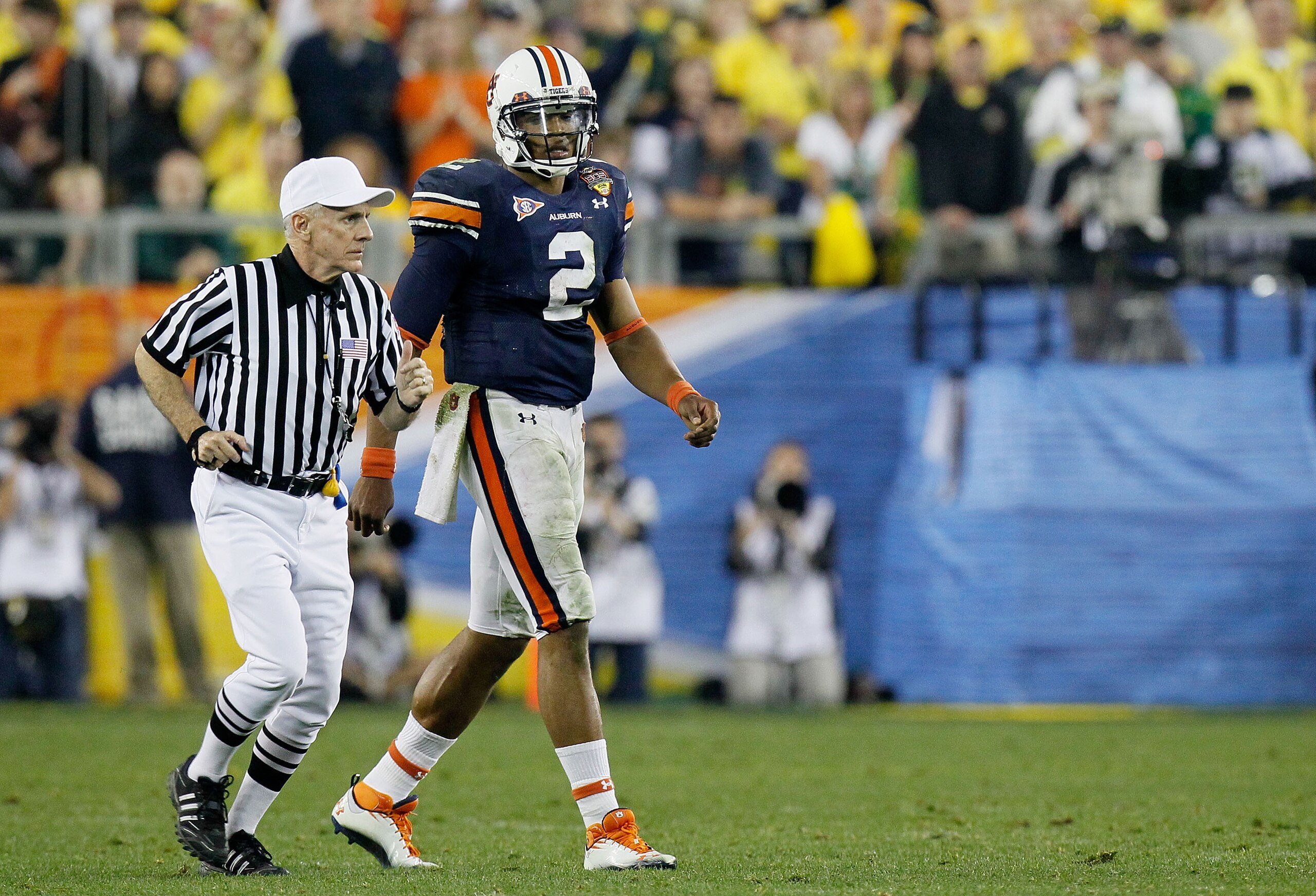 GLENDALE, AZ - JANUARY 10:  Cameron Newton #2 of the Auburn Tigers looks on as an official runs past during their game against the Oregon Ducks during the Tostitos BCS National Championship Game at University of Phoenix Stadium on January 10, 2011 in Glen