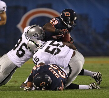 CHICAGO - AUGUST 21: Chester Taylor #29 of the Chicago Bears tries to break away from Kamerion Wimbley #96 and Rolando McClain #55 of the Oakland Raiders and past teammate Roberto Garza #63 during a preseason game at Soldier Field on August 21, 2010 in Ch CHICAGO - AUGUST 21: Chester Taylor #29 of the Chicago Bears tries to break away from Kamerion Wimbley #96 and Rolando McClain #55 of the Oakland Raiders and past teammate Roberto Garza #63 during a preseason game at Soldier Field on August 21, 2010 in Ch