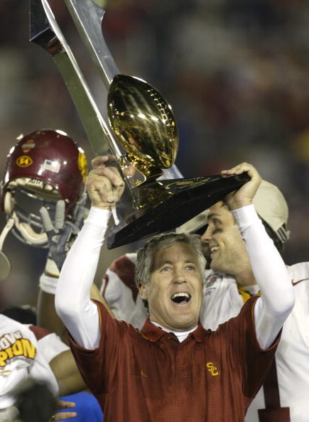 PASADENA, CA - JANUARY 1:  Head coach Pete Carroll of the USC Trojans celebrates with the Tournament of Roses trophy after defeating the Michigan Wolverines in the 2004 Rose Bowl on January 1, 2004 at the Rose Bowl in Pasadena, California. USC defeated Mi