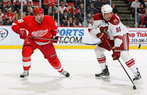 DETROIT - OCTOBER 28:  Ed Jovanovski #55 of the Phoenix Coyotes keeps an eye on the puck as does Tomas Holmstrom #96 of the Detroit Red Wings during their NHL game at Joe Louis Arena on October 28, 2010 in Detroit, Michigan.(Photo By Dave Sandford/Getty I