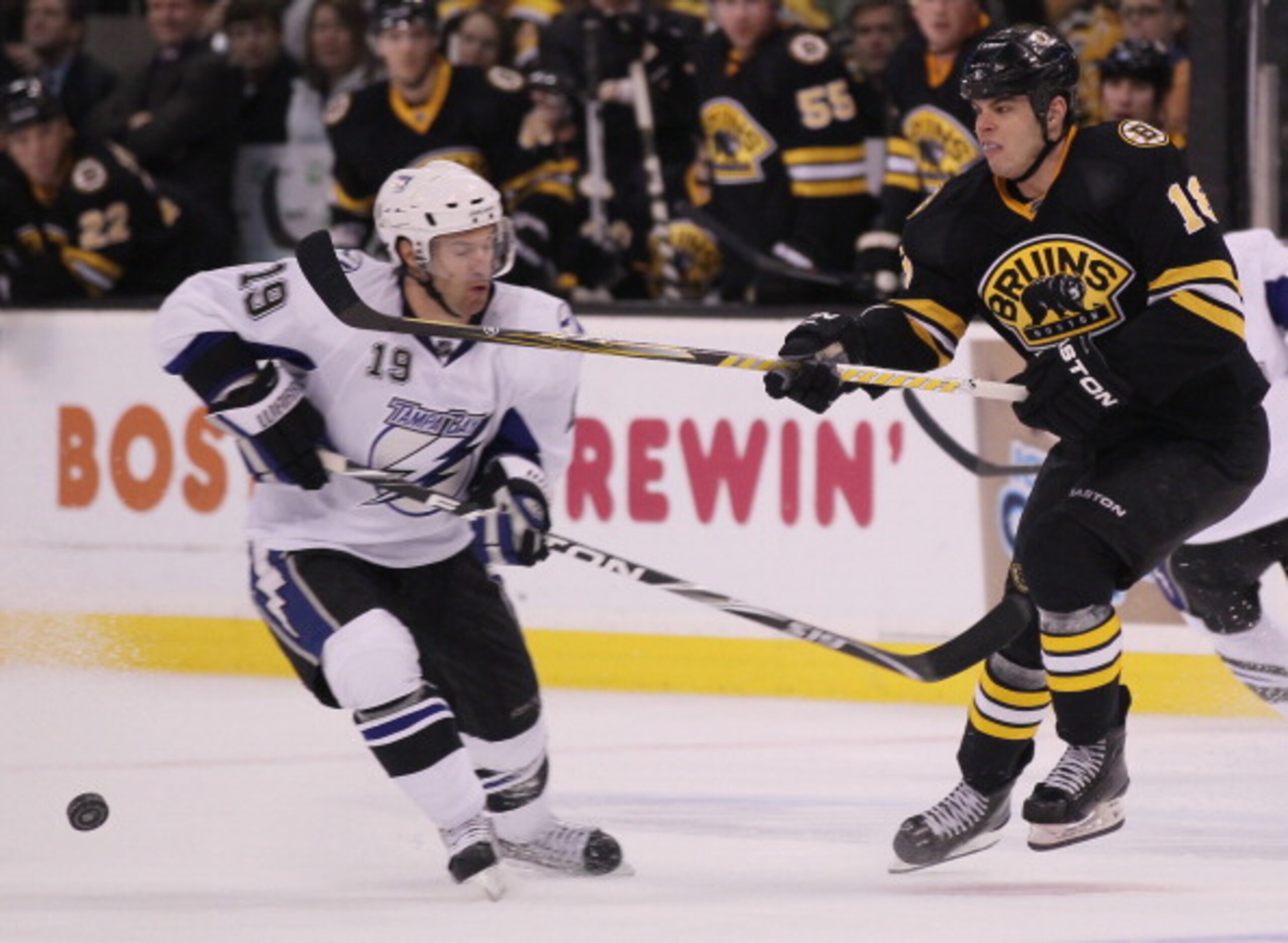 BOSTON, MA - MARCH 03:  Nathan Horton #18 of the Boston Bruins clears the puck as Dominic Moore #19 of the Tampa Bay Lightning nearly is hit on March 3, 2011 at the TD Garden in Boston, Massachusetts.  (Photo by Elsa/Getty Images)