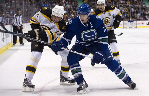 VANCOUVER, CANADA - FEBRUARY 26: Ryan Kesler #17 of the Vancouver Canucks battles with Tomas Kaberle #12 of the Boston Bruins while in the corner during the second period in NHL action on February 26, 2011 at Rogers Arena in Vancouver, British Columbia, C