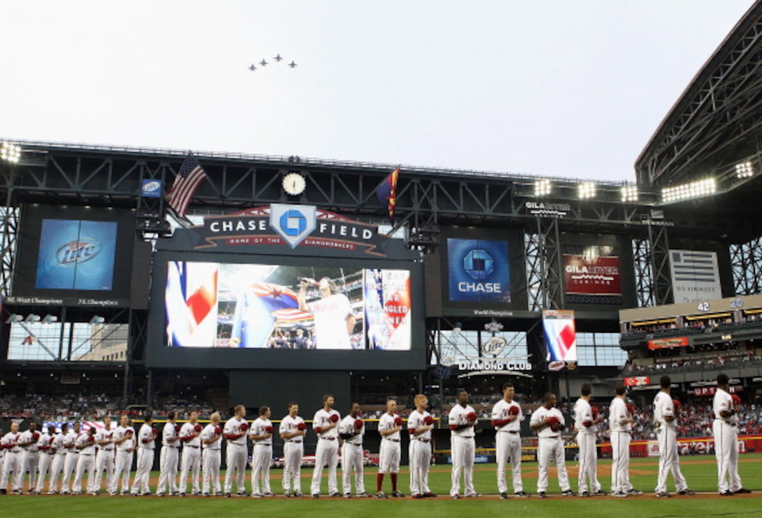 PHOENIX, AZ - APRIL 08: The Arizona Diamondbacks stand attended for the National Anthem as F-16's perform a fly over before the Major League Baseball home opening game against the Cincinnati Reds at Chase Field on April 8, 2011 in Phoenix, Arizona. (Pho PHOENIX, AZ - APRIL 08: The Arizona Diamondbacks stand attended for the National Anthem as F-16's perform a fly over before the Major League Baseball home opening game against the Cincinnati Reds at Chase Field on April 8, 2011 in Phoenix, Arizona. (Pho