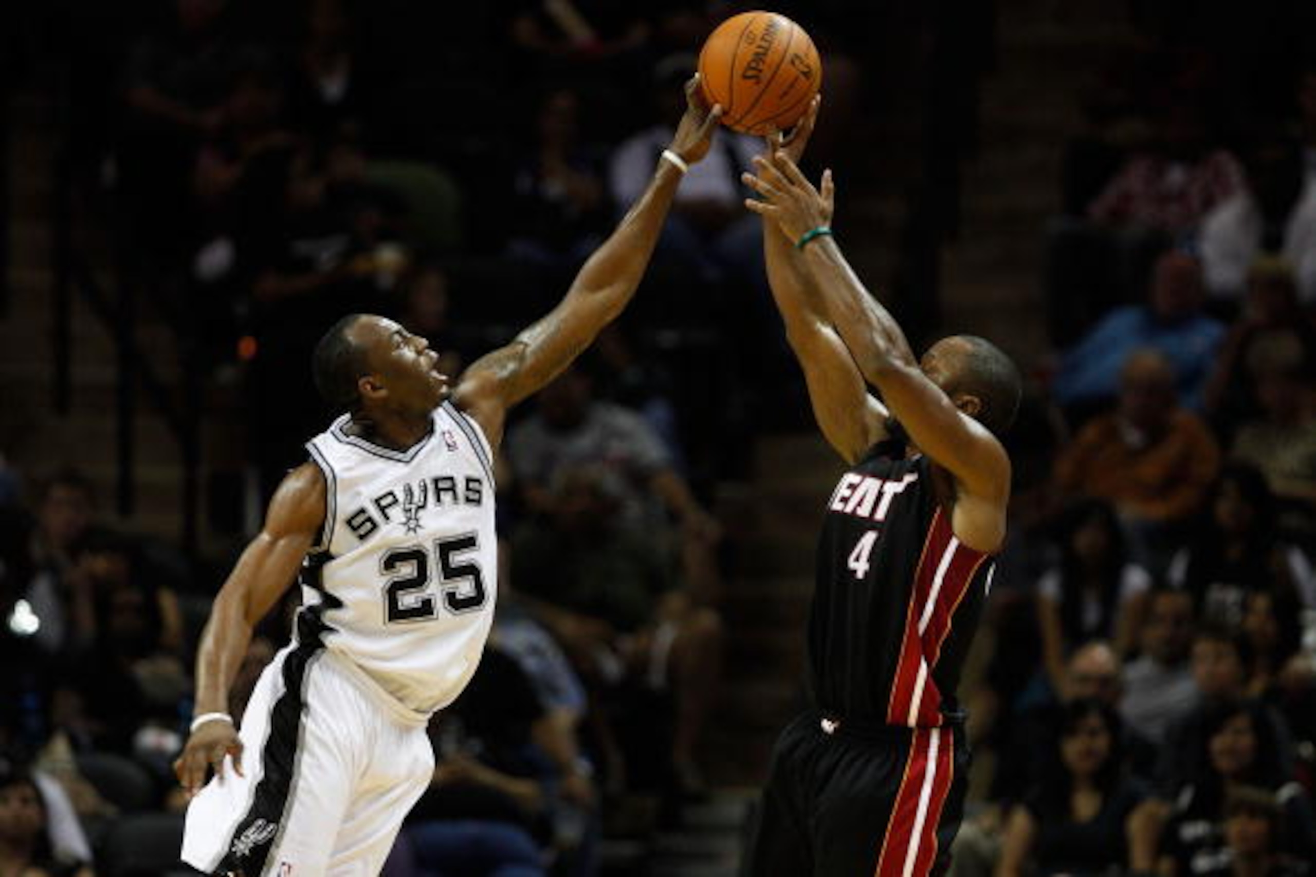 SAN ANTONIO - OCTOBER 09:  Kenny Hasbrouck #4 of the Miami Heat has a shot blocked by James Anderson #25 of the San Antonio Spurs at the AT&T Center on October 9, 2010 in San Antonio, Texas.  NOTE TO USER: User expressly acknowledges and agrees that, by d