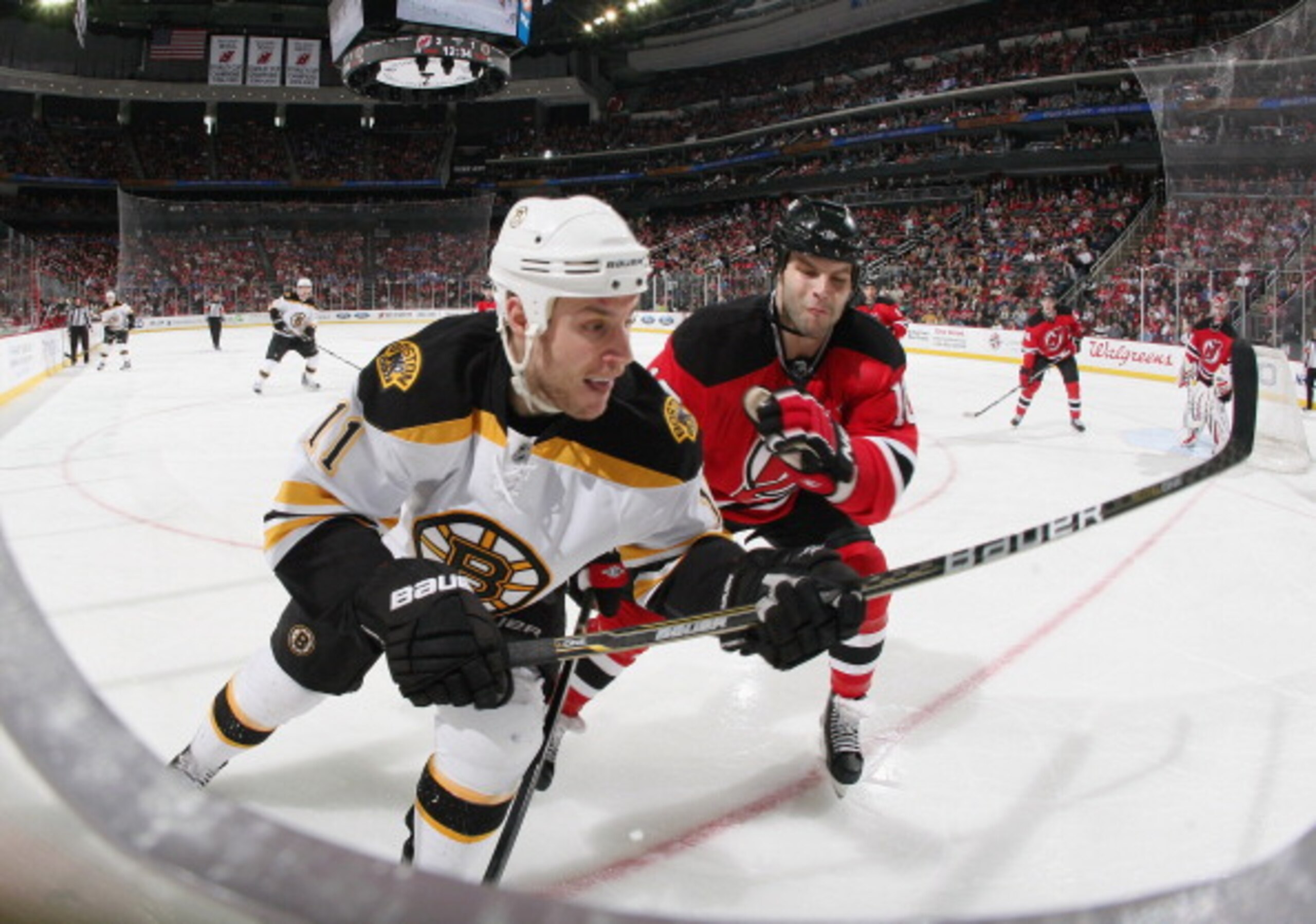 NEWARK, NJ - APRIL 10: Rod Pelley #10 of the New Jersey Devils checks Gregory Campbell #11 of the Boston Bruins at the Prudential Center on April 10, 2011 in Newark, New Jersey.  The Devils defeated the Bruins 3-2. (Photo by Bruce Bennett/Getty Images)