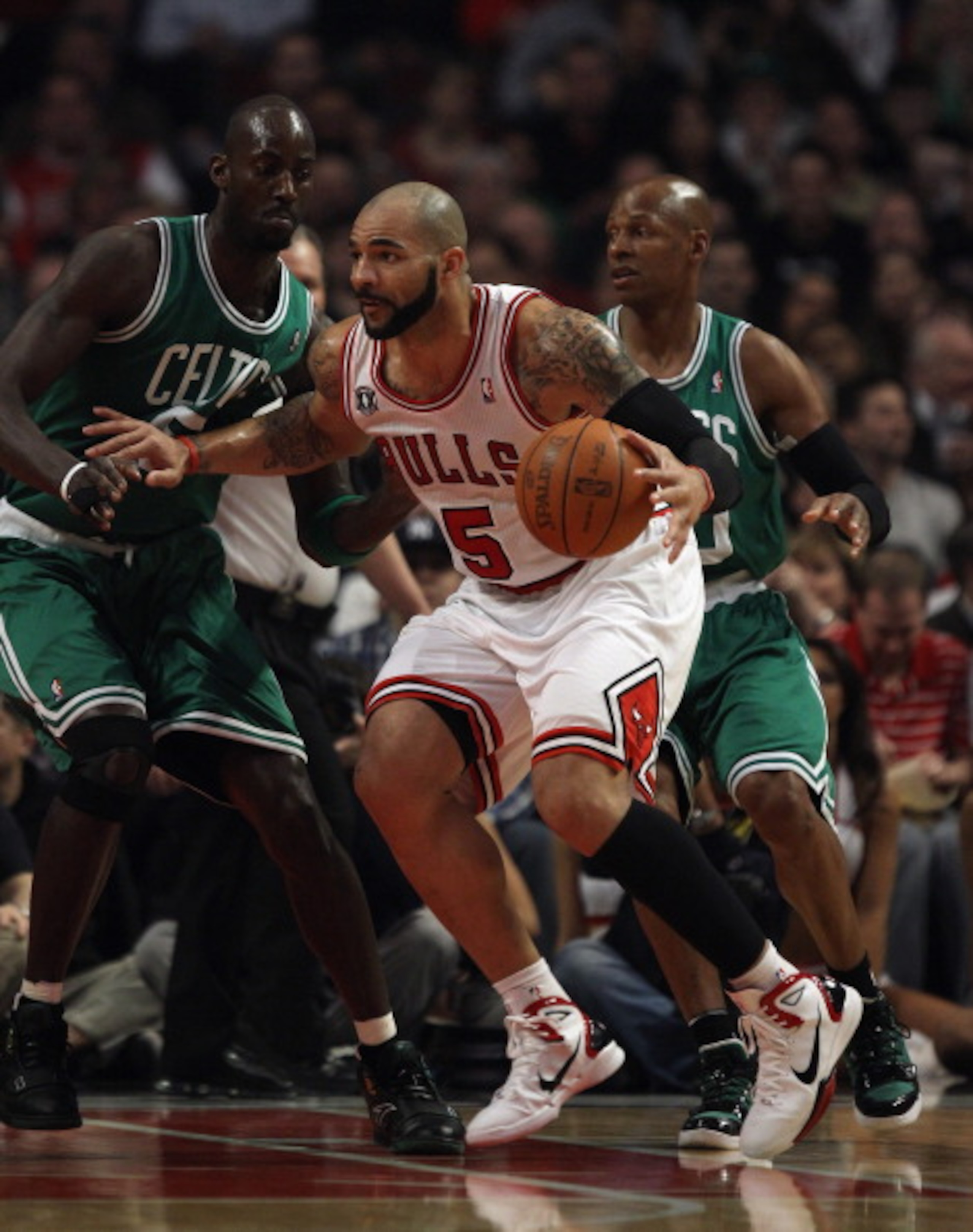 CHICAGO, IL - APRIL 07: Carlos Boozer #5 of the Chicago Bulls moves against Kevin Garnett #5 (L) and Ray Allen #20 of the Boston Celtics at United Center on April 7, 2011 in Chicago, Illinois. The Bulls defeated the Celtics 97-81. NOTE TO USER: User expre CHICAGO, IL - APRIL 07: Carlos Boozer #5 of the Chicago Bulls moves against Kevin Garnett #5 (L) and Ray Allen #20 of the Boston Celtics at United Center on April 7, 2011 in Chicago, Illinois. The Bulls defeated the Celtics 97-81. NOTE TO USER: User expre