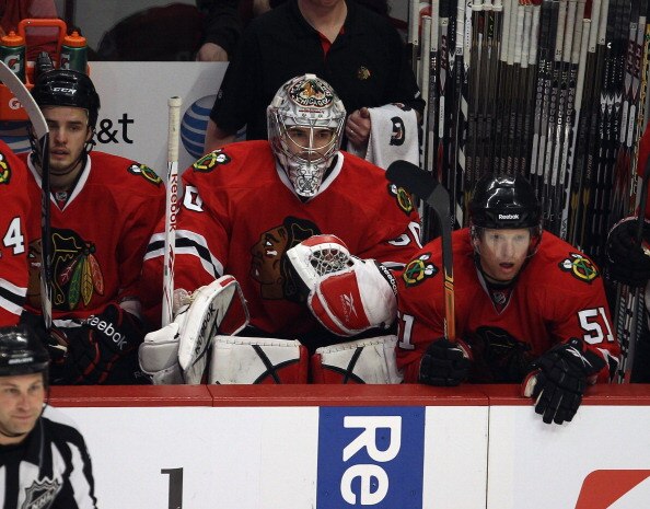 CHICAGO, IL - APRIL 10: Corey Crawford #50 of the Chicago Blackhawks (C) watches the final seconds of the regualr season-ending game against the Detroit Red Wings from the bench between teammates Niklas Hjalmarsson #4 (L) and Brian Campbell #51 at the Uni