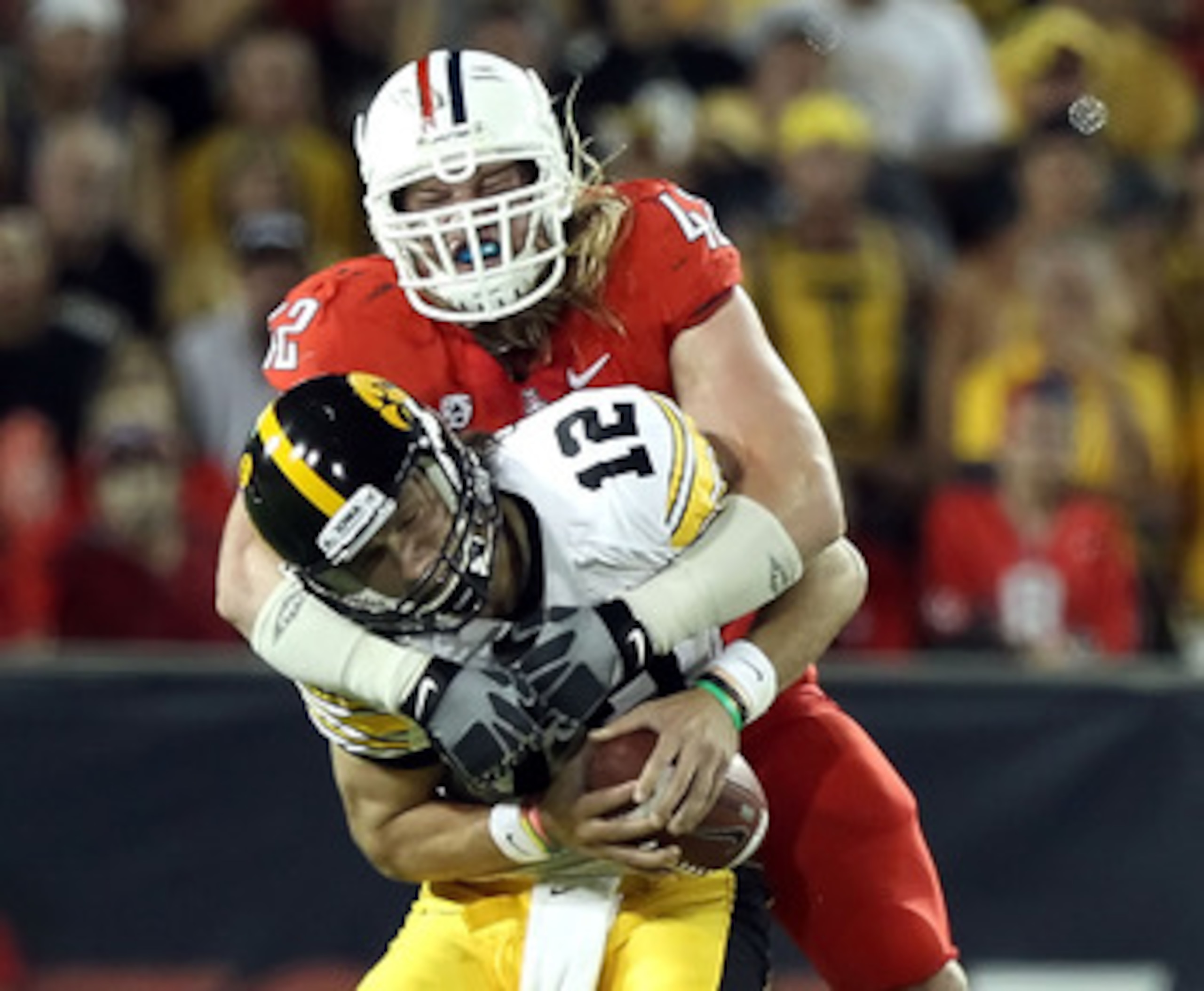 TUCSON, AZ - SEPTEMBER 18:  Quarterback Ricky Stanzi #12 of the Iowa Hawkeyes is sacked by Brooks Reed #42 of the Arizona Wildcats during the third quarter of the college football game at Arizona Stadium on September 18, 2010 in Tucson, Arizona.  The Wild