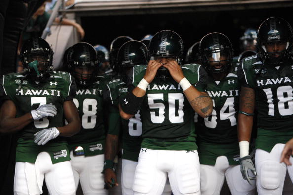 HONOLULU - SEPTEMBER 02: Mana Lolotai #50 of the University of Hawaii Warriors checks his helmet before the Warriors take the field in their season opener against the University of Southern California Trojans at Aloha Stadium September 2, 2010 in Honolulu