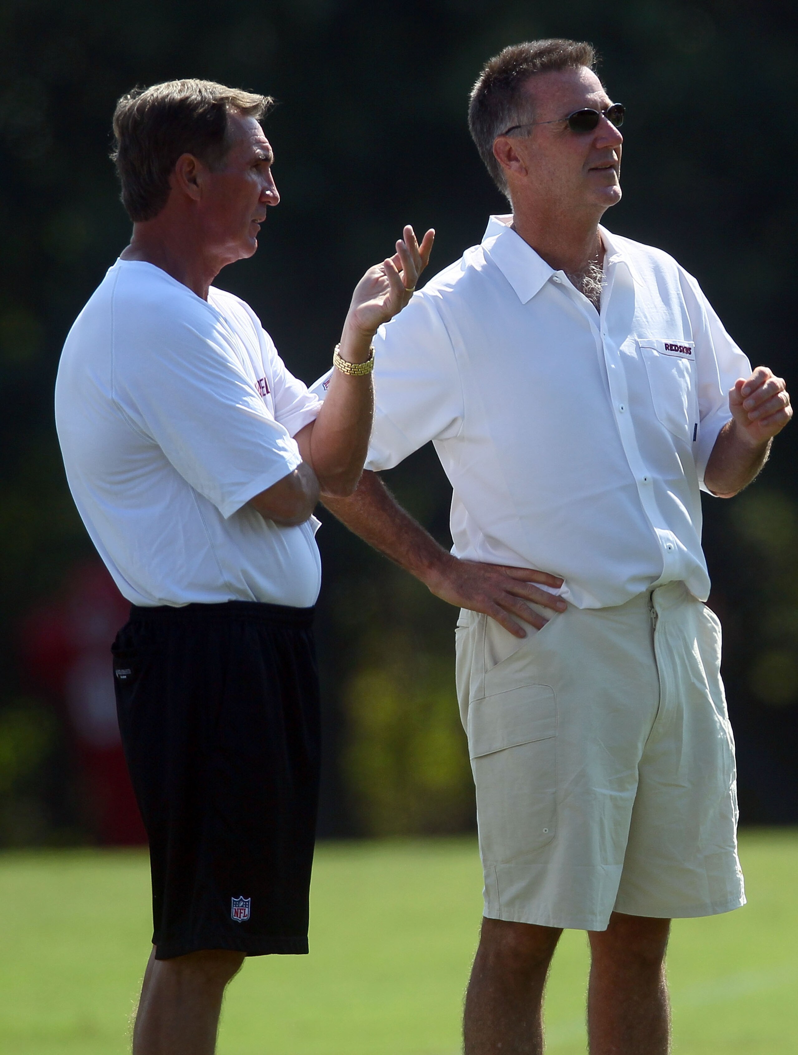 ASHBURN, VA - JULY 30:  Head coach Mike Shanahan (L) of the Washington Redskins speaks with general manager Bruce Allen during the second day of training camp July 30, 2010 in Ashburn, Virginia.  (Photo by Win McNamee/Getty Images)
