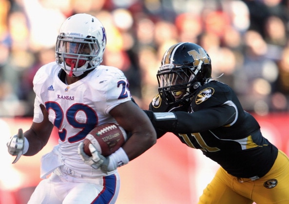 KANSAS CITY, MO - NOVEMBER 27:  James Sims #29 of the Kansas Jayhawks carries the ball as Jarrell Harrison #11 of the Missouri Tigers defends during the game on November 27, 2010 at Arrowhead Stadium in Kansas City, Missouri.  (Photo by Jamie Squire/Getty