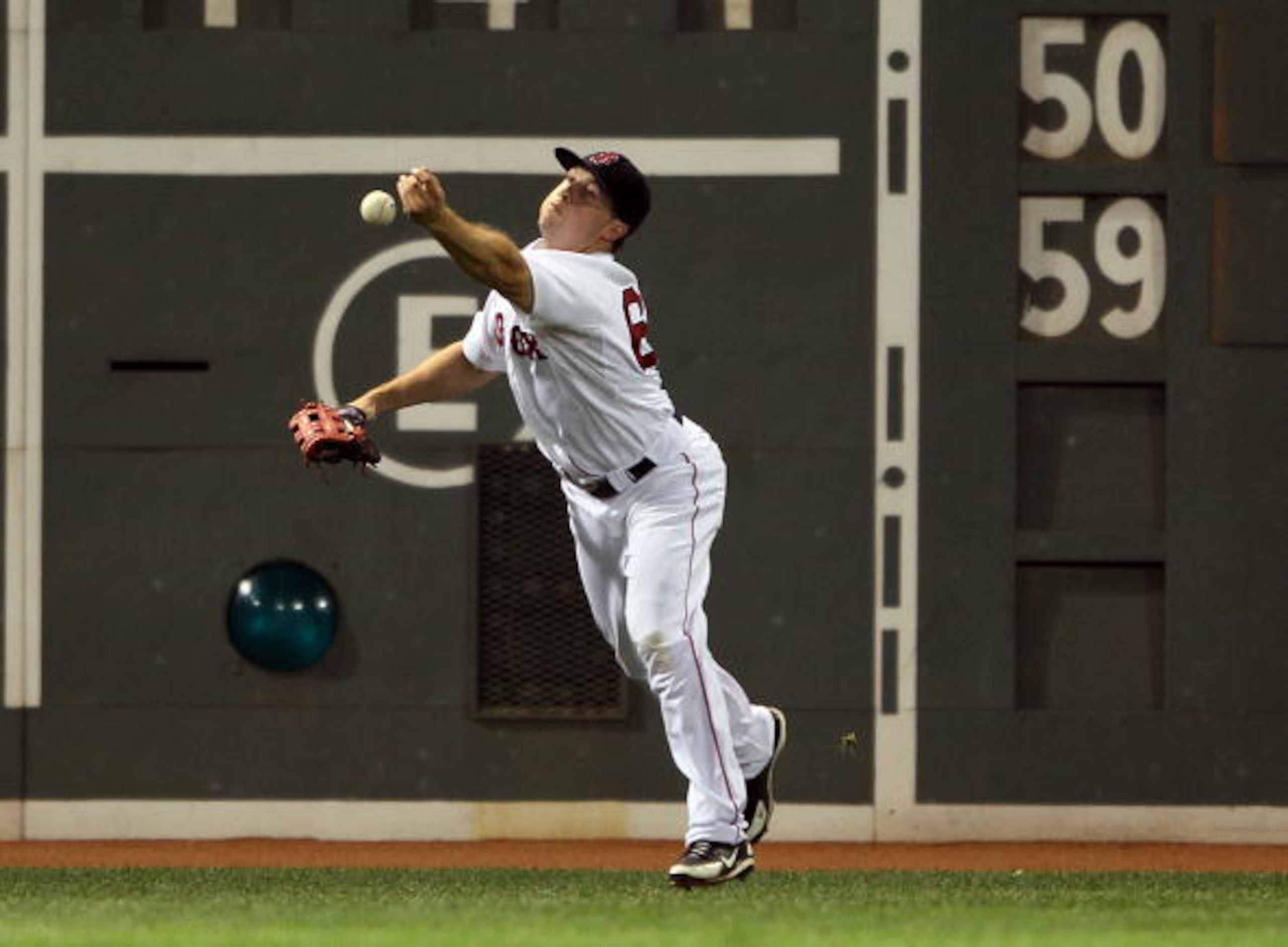 BOSTON - JULY 15:  Daniel Nava #60 of the Boston Red Sox is unable to make the catch off the Green Monster in the seventh inning against the Texas Rangers on July 15, 2010 at Fenway Park in Boston, Massachusetts.  (Photo by Elsa/Getty Images)