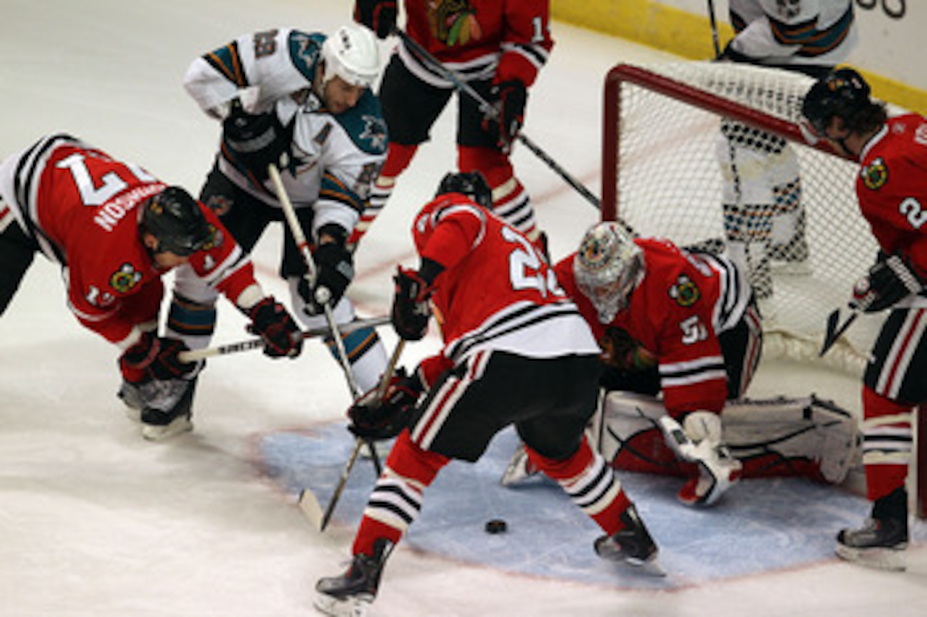CHICAGO, IL - MARCH 14: Corey Crawford #50 of the Chicago Blackhawks makes a save as teammates Ryan Johnson #17 and Troy Brouwer #22 defend against a shot by Ryane Clowe #29 of the San Jose Sharks at the United Center on March 14, 2011 in Chicago, Illinoi