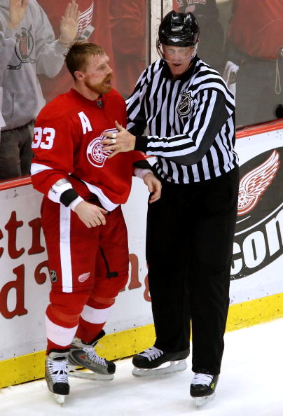 DETROIT - MAY 10:  Kris Draper #33 of the Detroit Red Wings is talked to by linesman Jean Morin after a scrum in game two of the Western Conference Finals of the 2008 NHL Stanley Cup Playoffs against the Dallas Stars at Joe Louis Arena on May 10, 2008 in