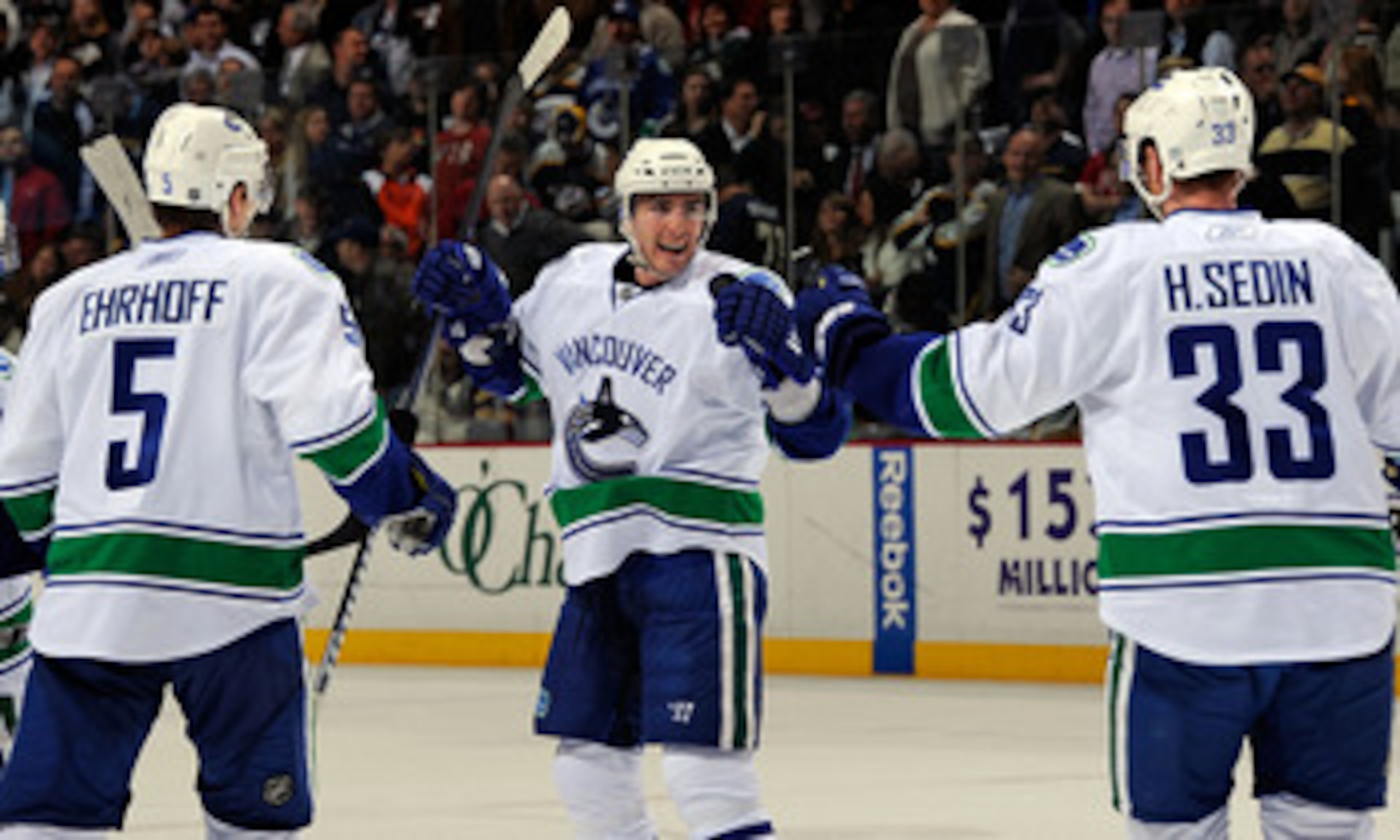 NASHVILLE, TN - MARCH 29:  Christian Ehrhoff #5 and Henrik Sedin #33 of the Vancouver Canucks congratulate teammate Alexandre Burrows #14 on scoring a goal against the Nashville Predators on March 29, 2011 at the Bridgestone Arena in Nashville, Tennessee.