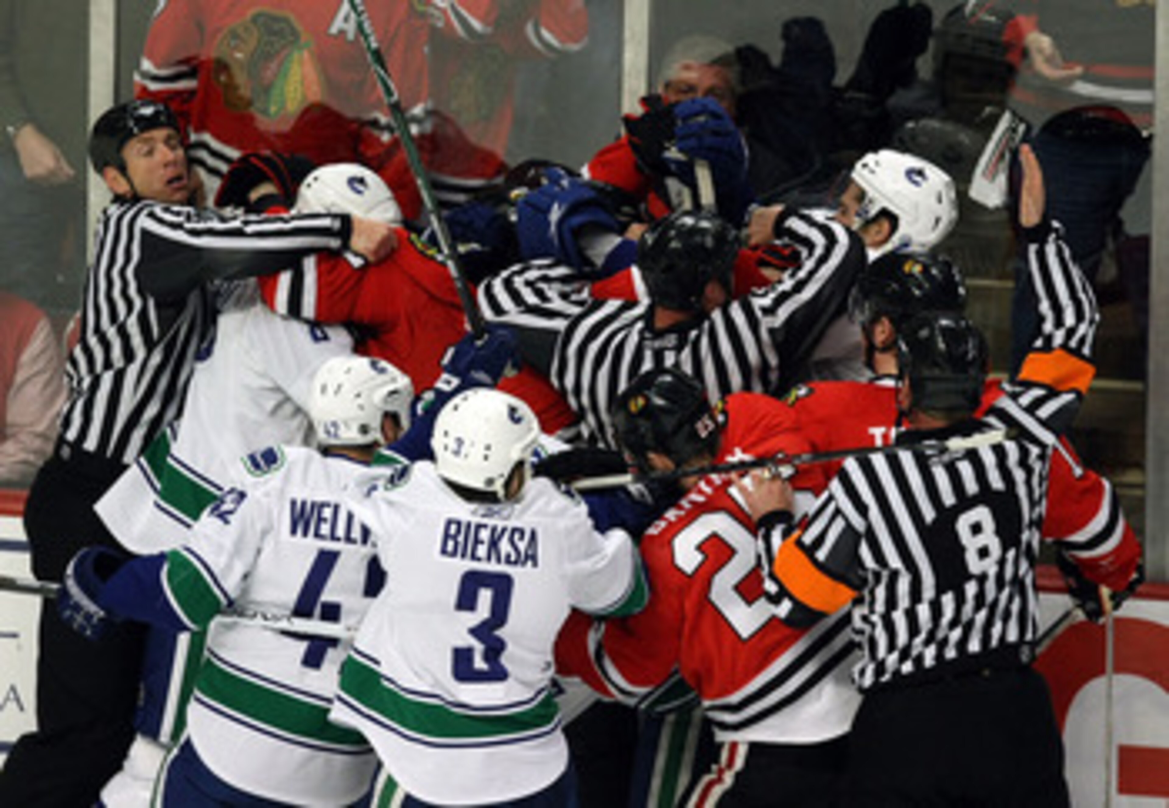 CHICAGO - MAY 05:  Officials attempt to seperate players from the Chicago Blackhawks and the Vancouver Canucks as they fight along the boards during the first period of Game Three of the Western Conference Semifinal Round of the 2009 Stanley Cup Playoffs